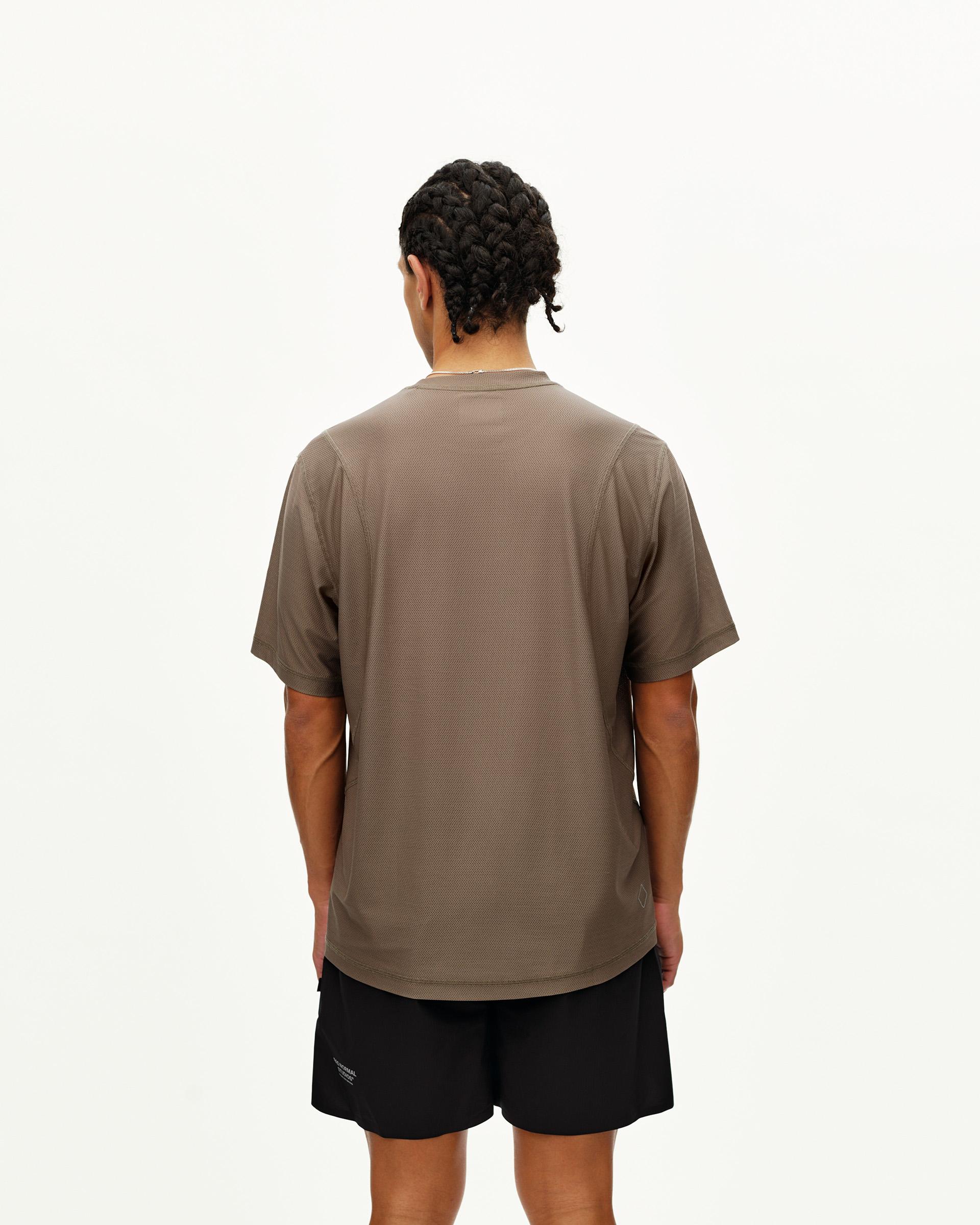 Stone Brown Balance T-shirt on model, rear view with curved hem and textured fabric