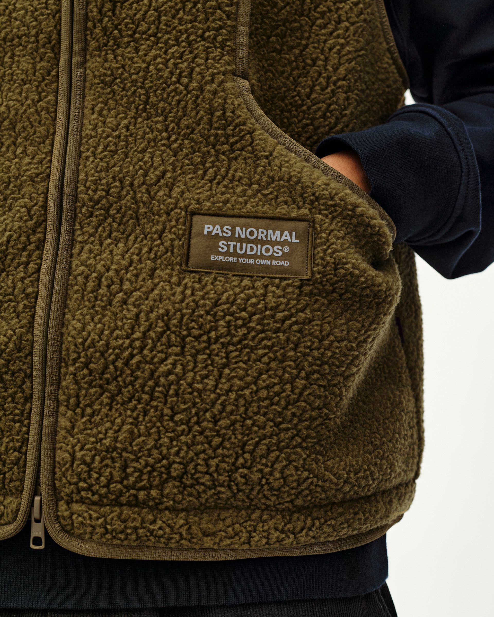 Deep Olive Off-Race Pile Fleece vest on model, front detail view with sherpa texture and branded chest patch