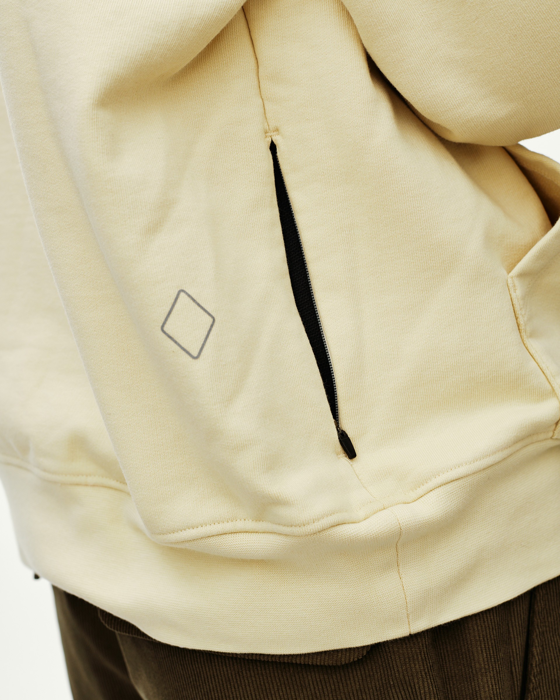 Sand Off-Race hoodie, detail view of zip pocket with diamond logo print