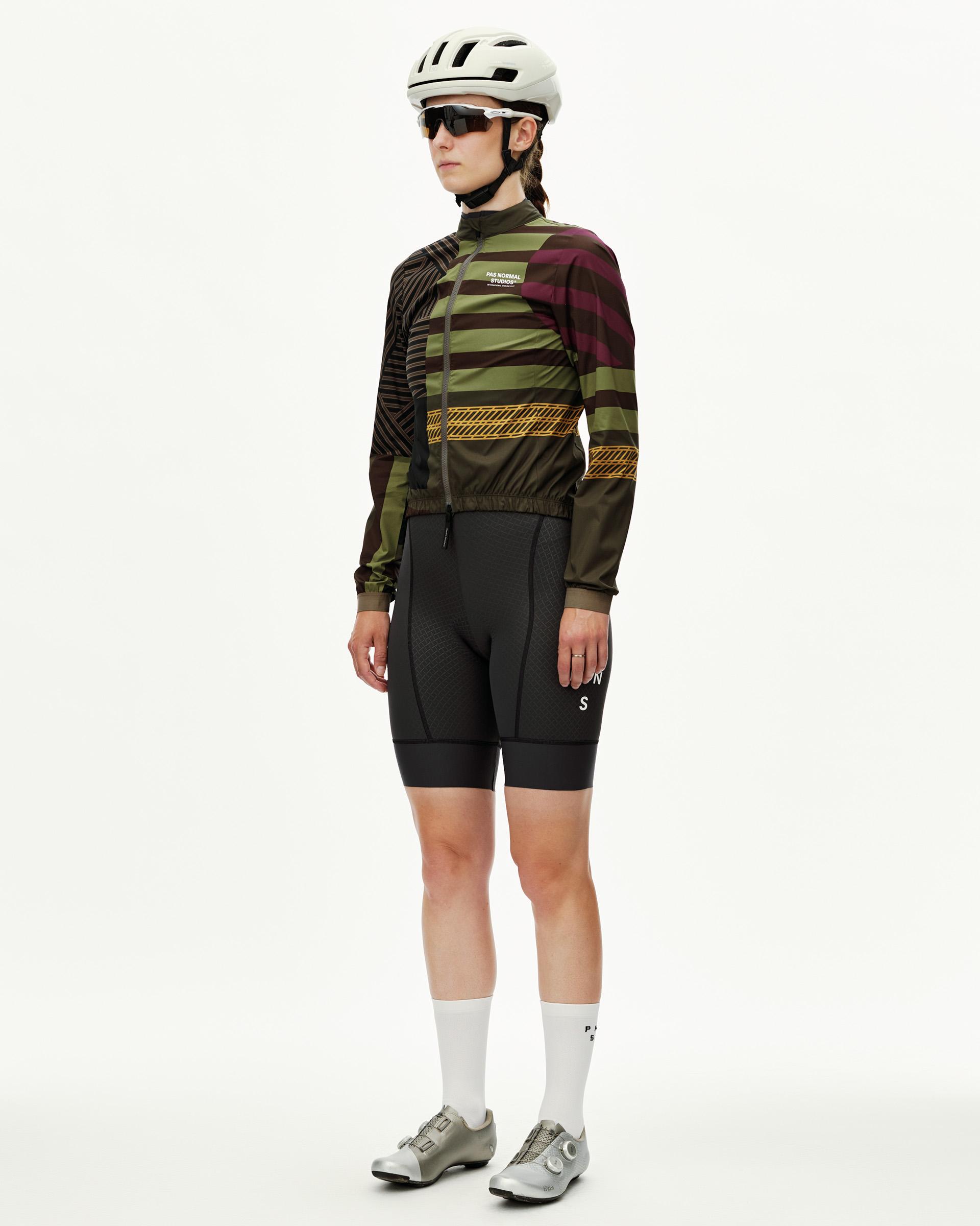 International Green Mechanism Stow Away women's cycling jacket on model, three-quarter front view with multicolor stripes