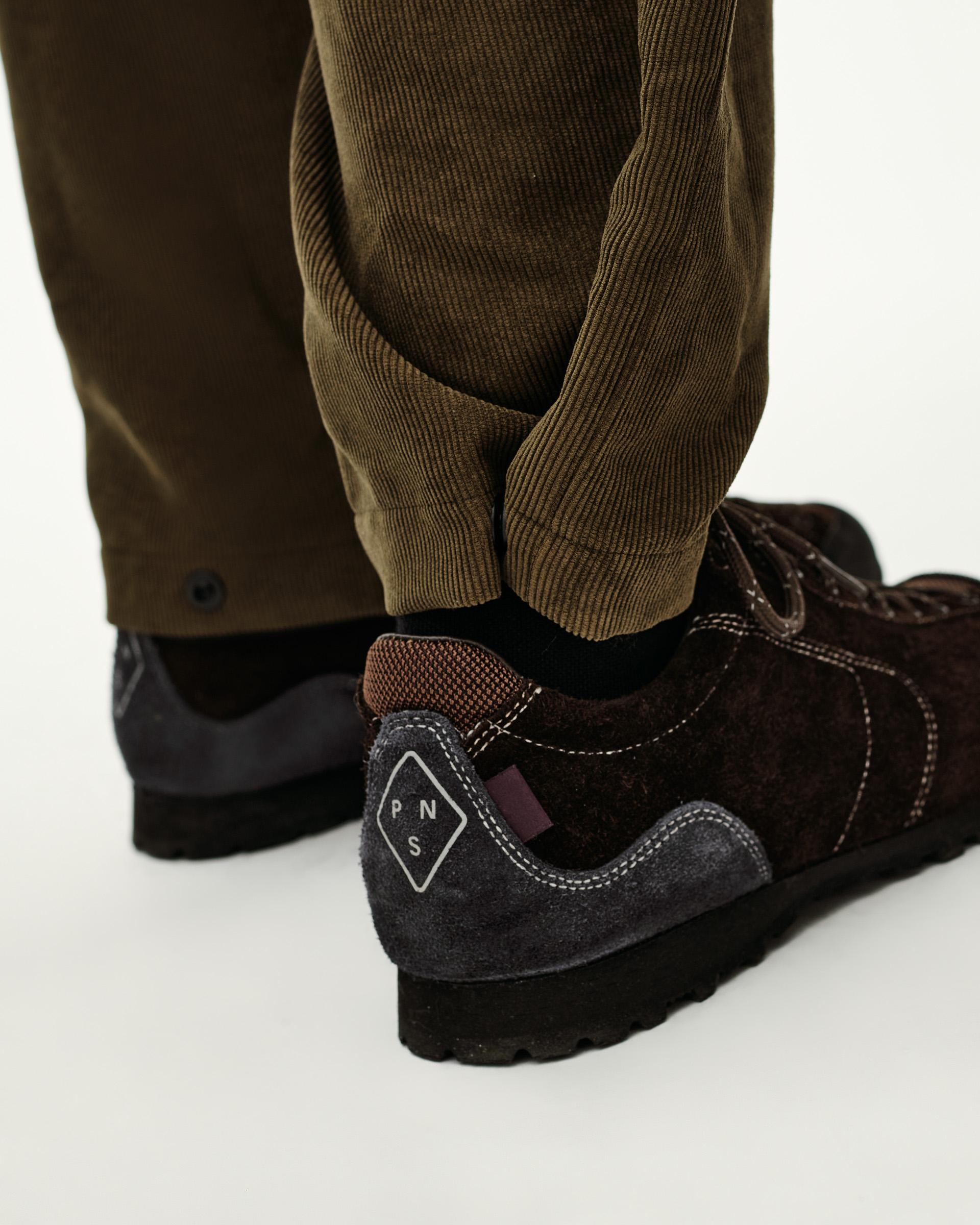 Deep Olive Off-Race corduroy pants on model, rear detail view with ribbed ankle cuff