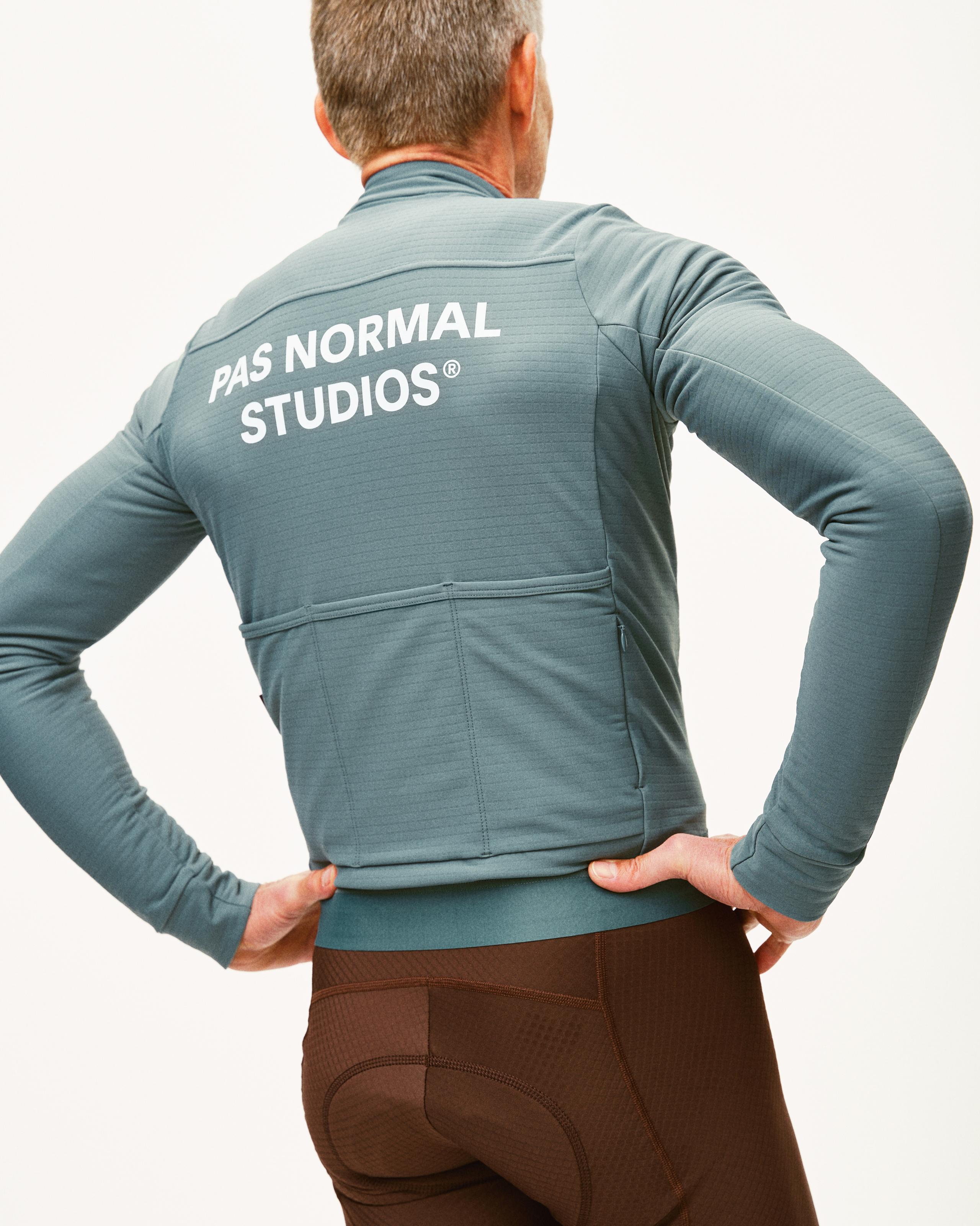 Grey Essential long sleeve cycling jersey on model, rear view with white back logo