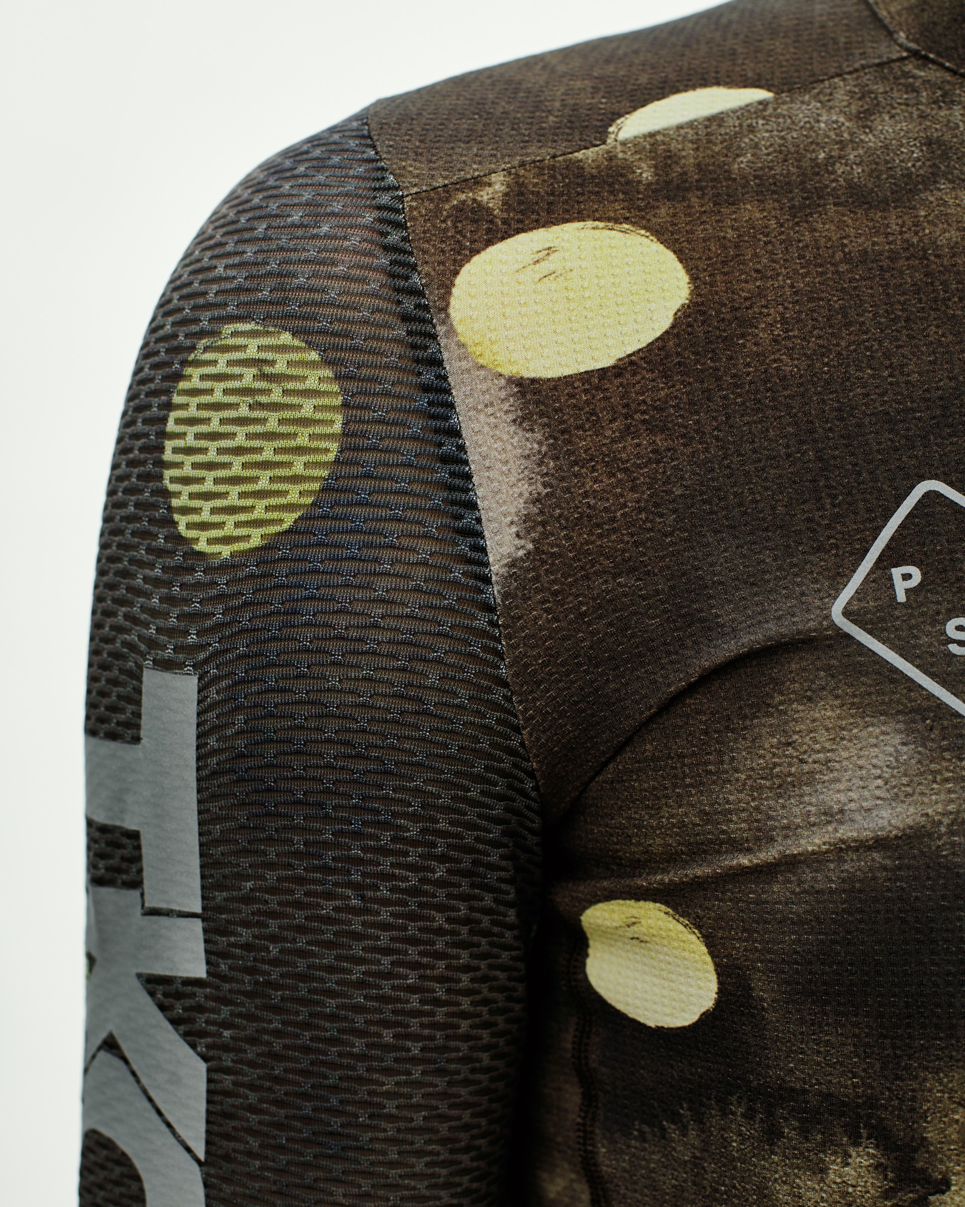 Green T.K.O. Essential Light cycling jersey, detail view showing yellow circle print and mesh side panel