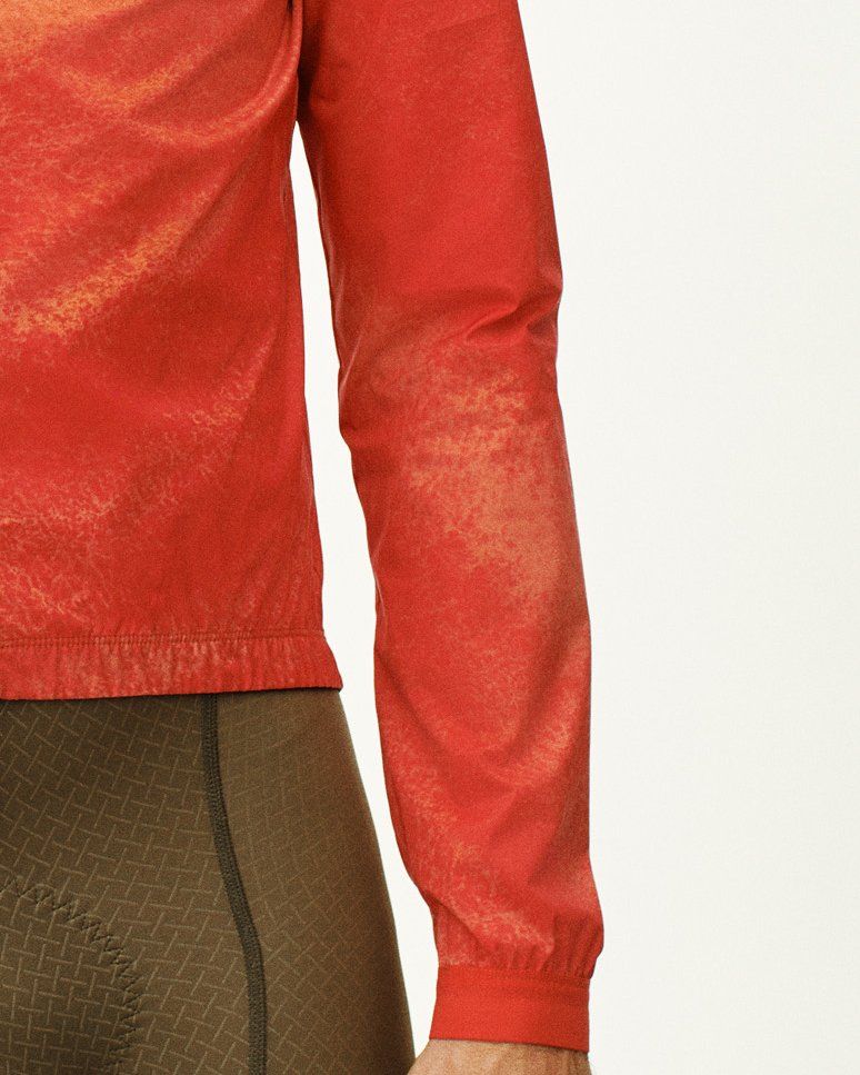 Red Mechanism Stow Away jacket, side detail view showing elastic cuffs and hem