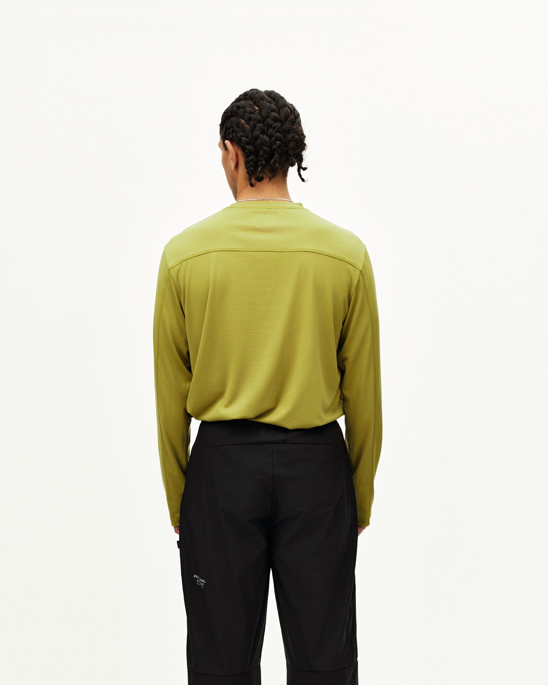 Black Balance performance pants on model, rear view with side utility pocket detail