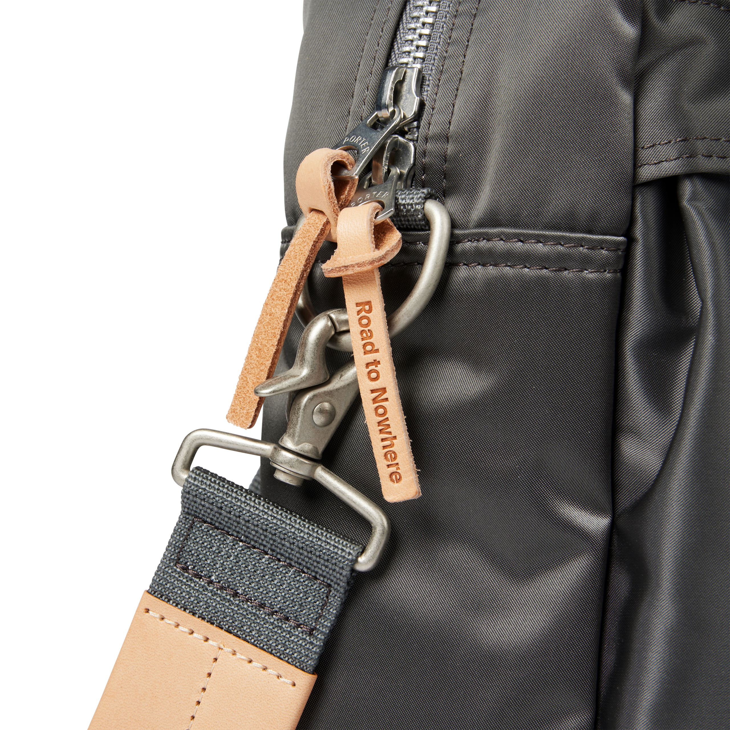 Grey Porter-Yoshida 2-Way briefcase, detail view with leather strap hardware and branded tag