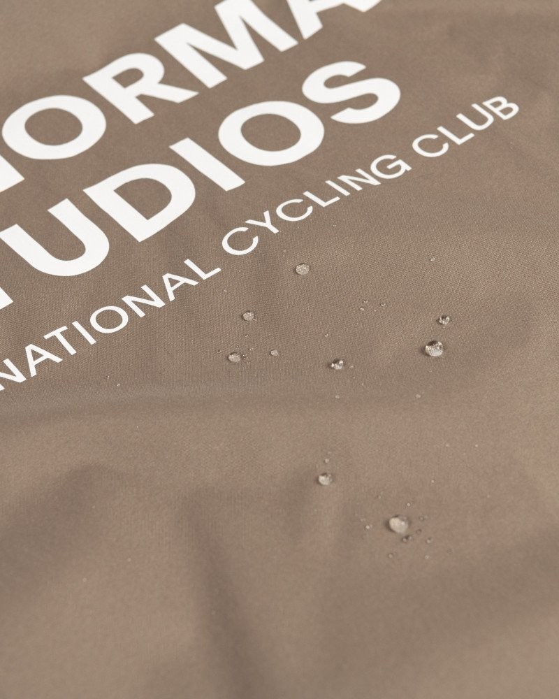 Beige Mechanism Stow Away gilet detail view showing water-repellent fabric with beaded droplets