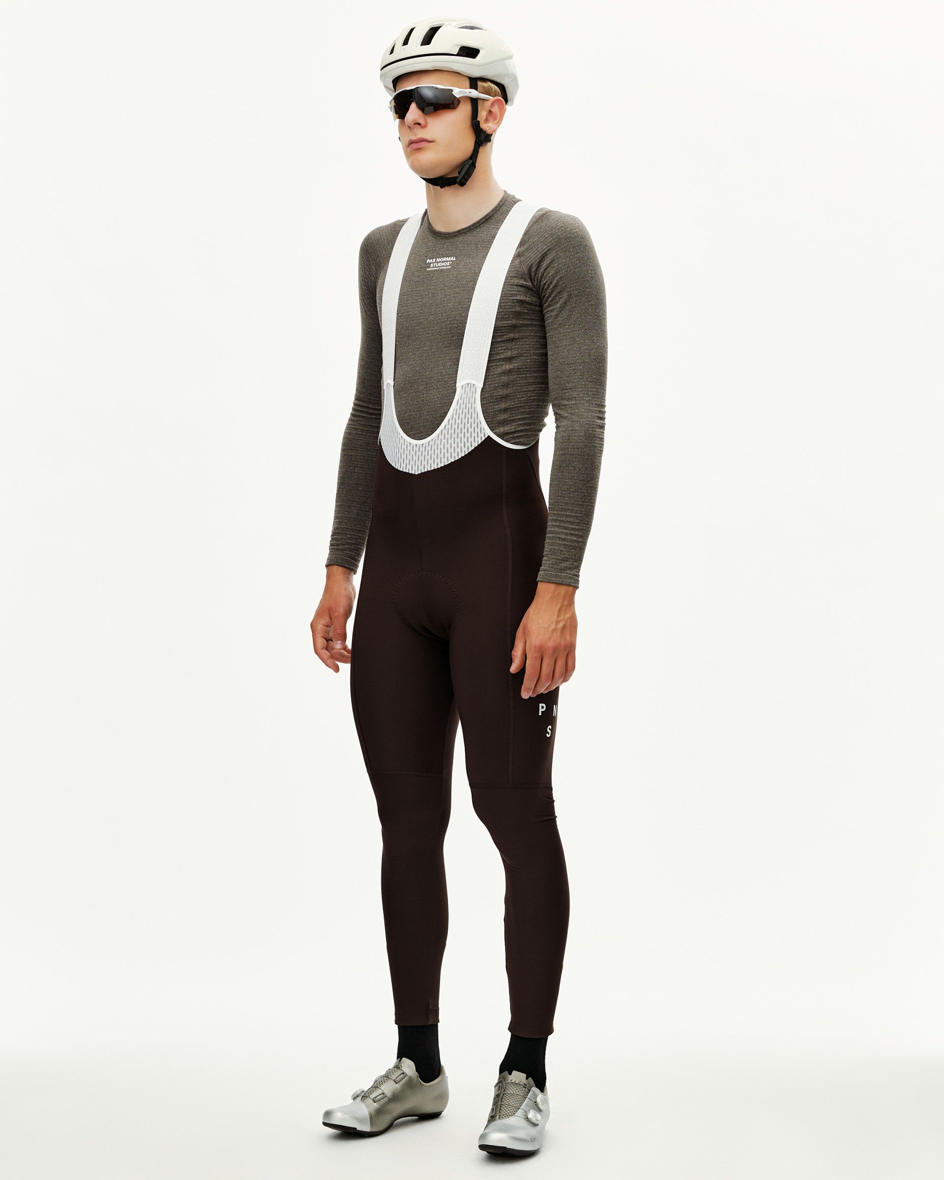 Dark Coffee Mechanism men's thermal cycling bib tights on model, three-quarter front view with white mesh bib straps
