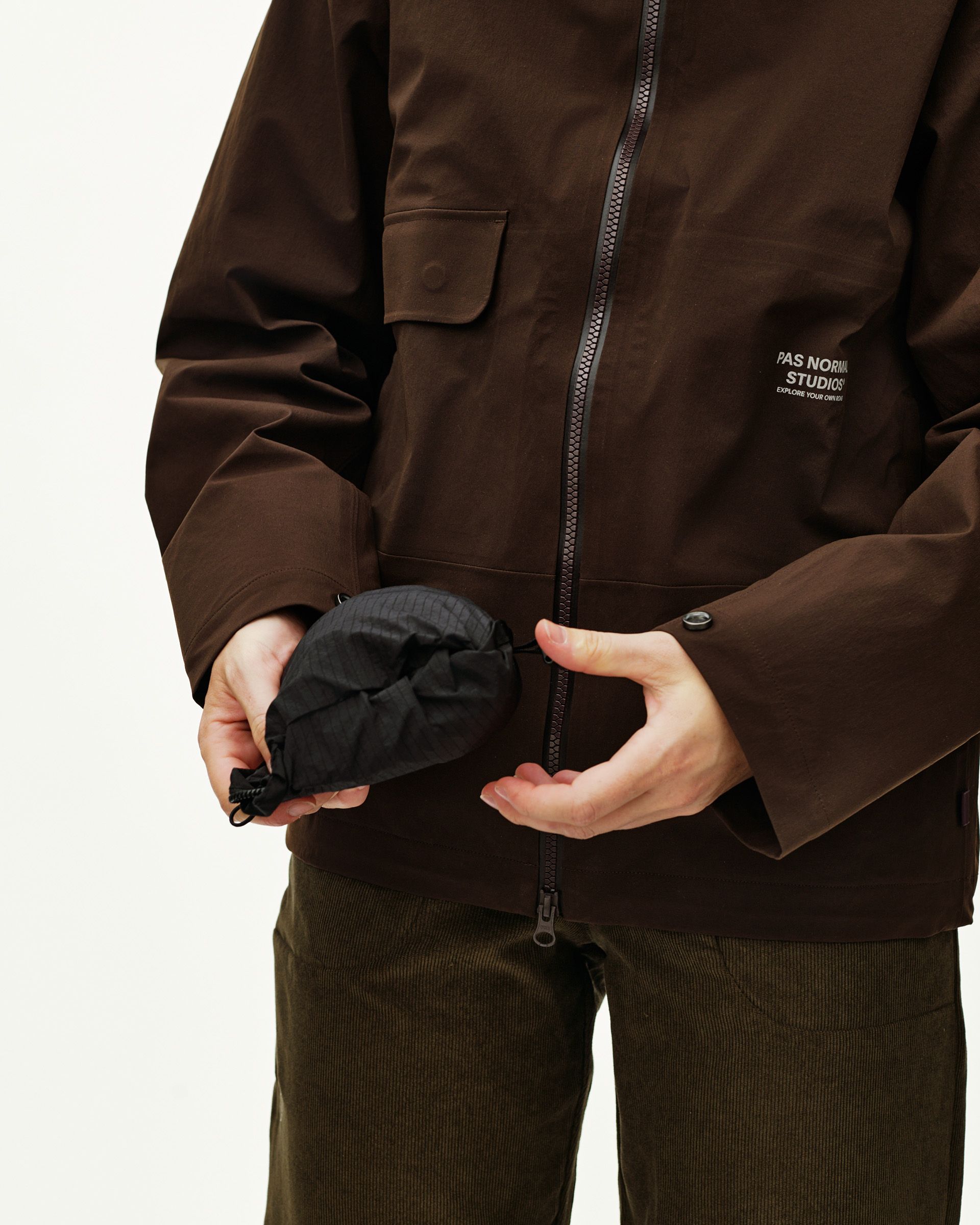 Black Off-Race Tech Musette 2.0 bag, detail view held in hand showing packable drawstring pouch