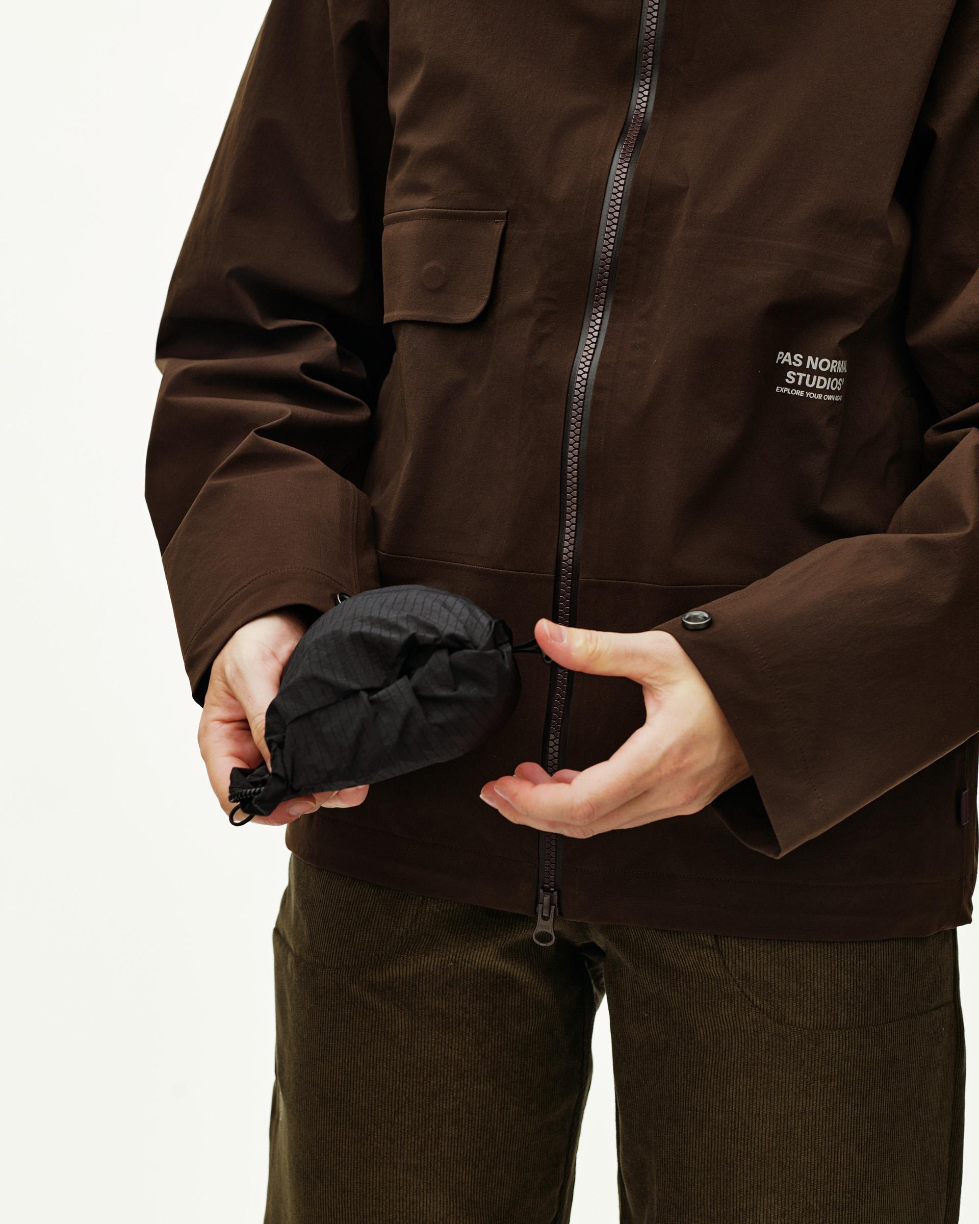 Black Off-Race Tech Musette 2.0 bag, detail view held in hand showing packable drawstring pouch