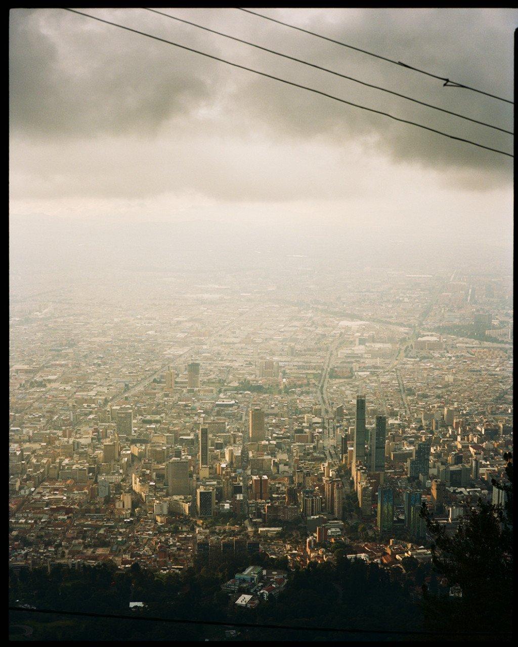 Aerial view of Bogotá cityscape with cloudy sky and urban sprawl