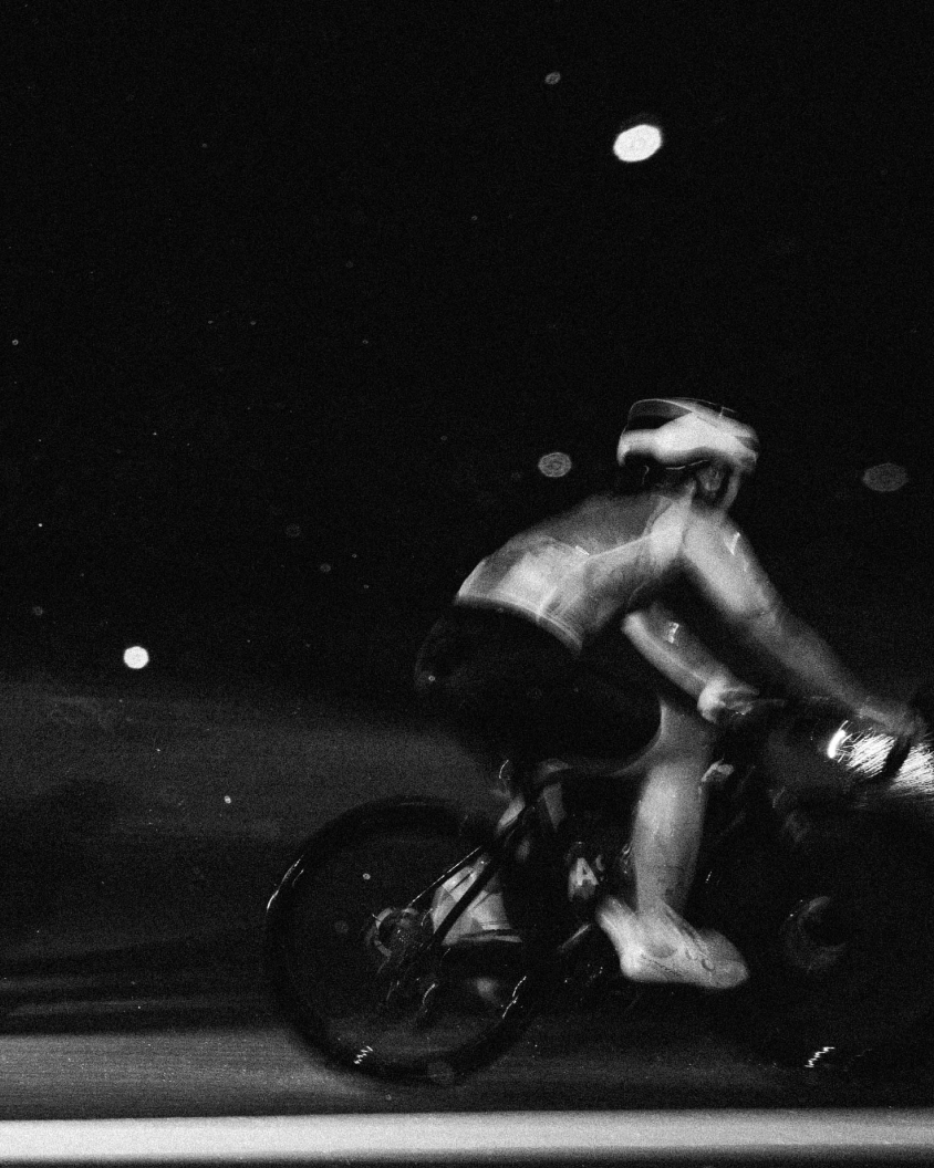 Model cycling at night in black and white with motion blur