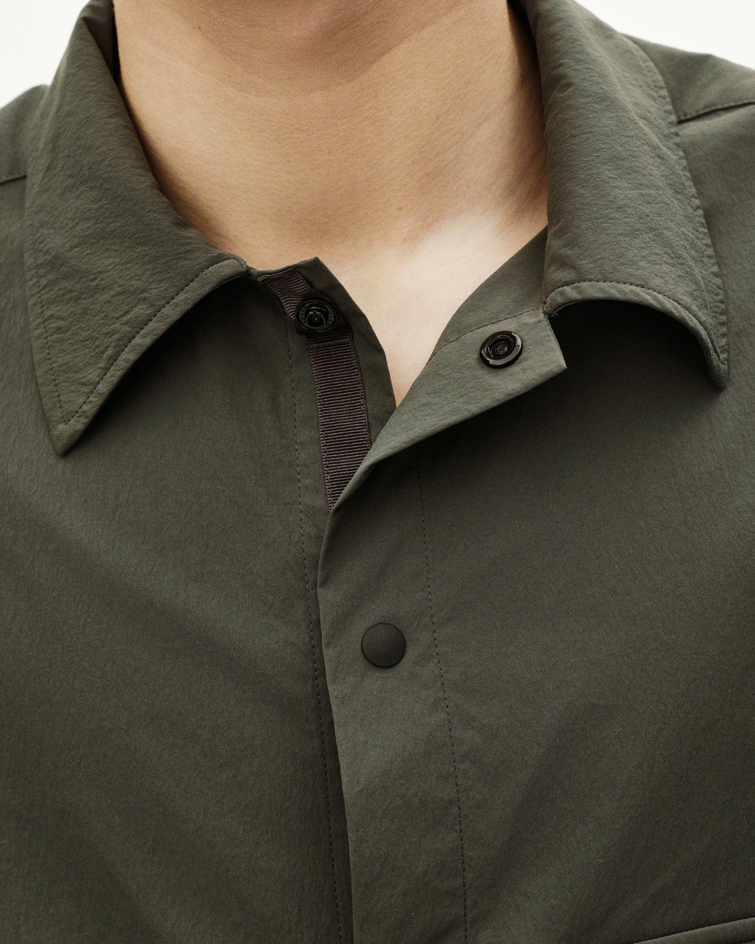 Olive green shirt collar and front placket with snap button closures