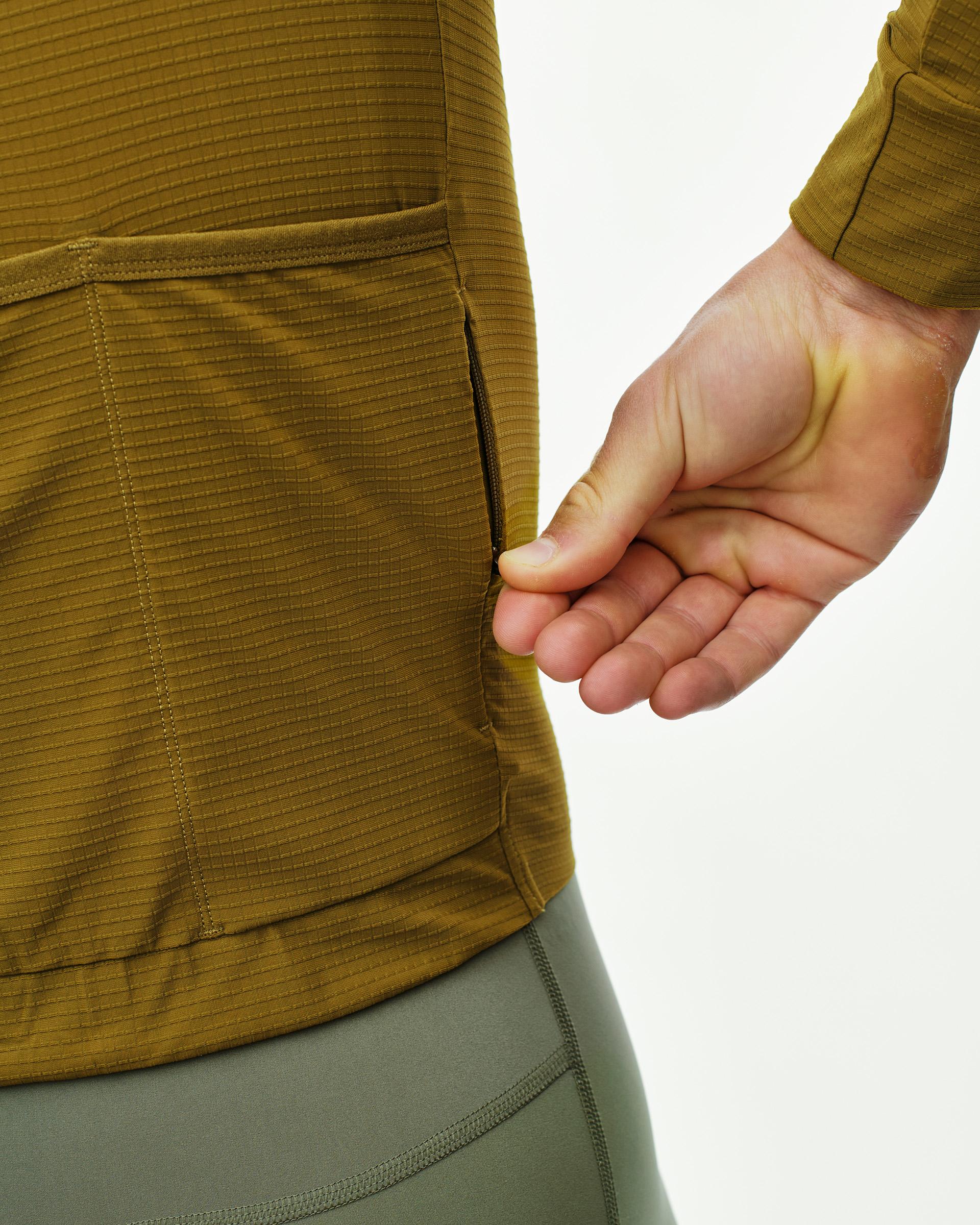 Khaki Green PAS Mechanism Pro long sleeve cycling jersey on model showing ribbed texture and rear zip pocket
