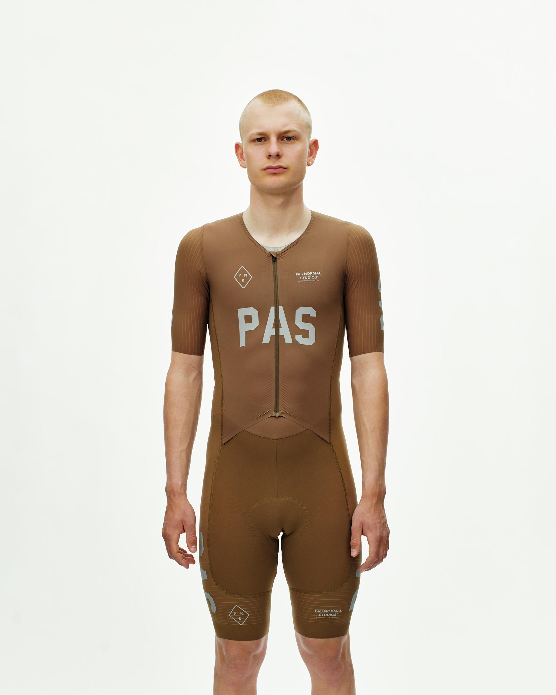 Brown PAS Mechanism Pro speedsuit on model, front view with white chest logo