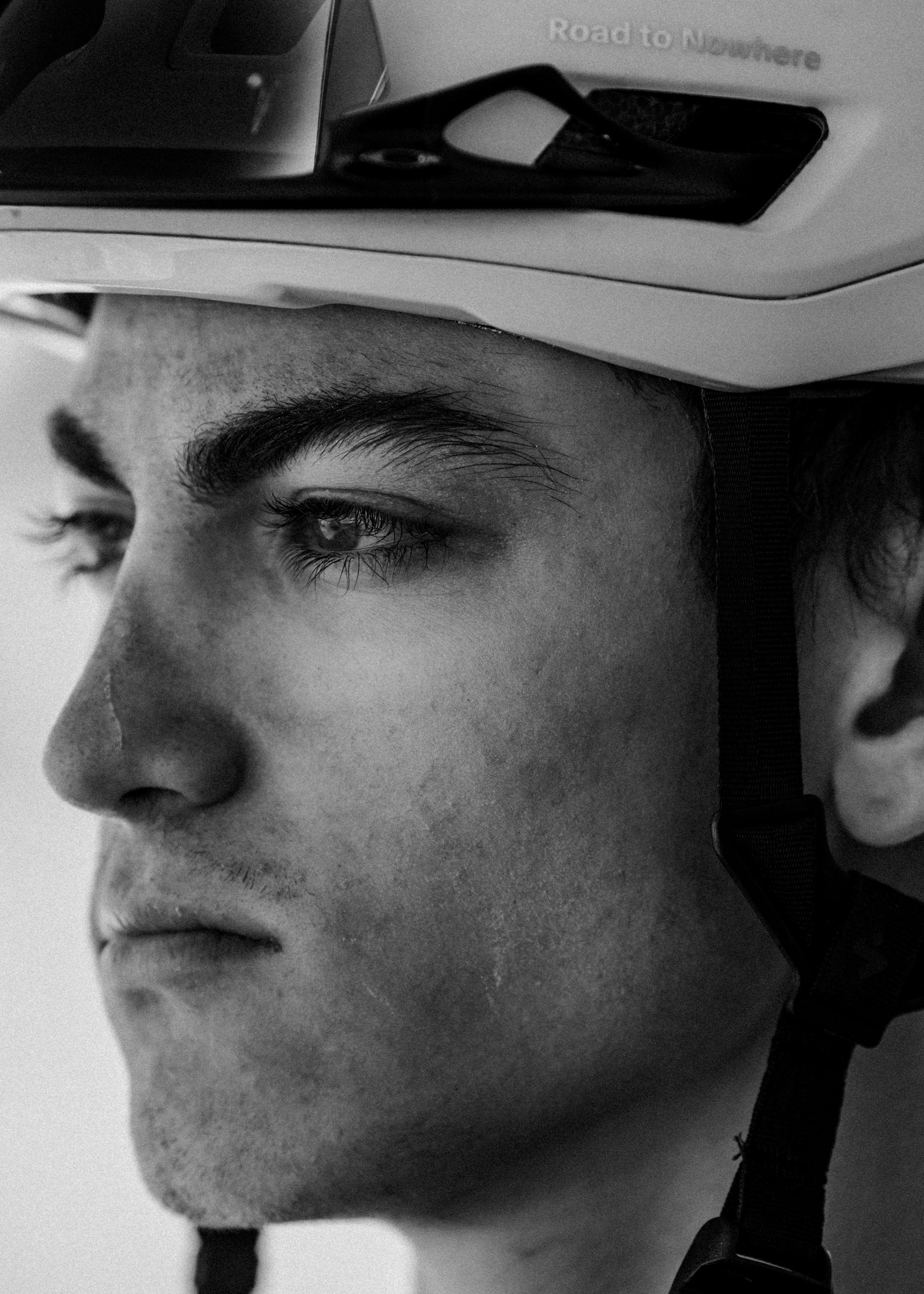 Model wearing white cycling helmet in black and white portrait shot