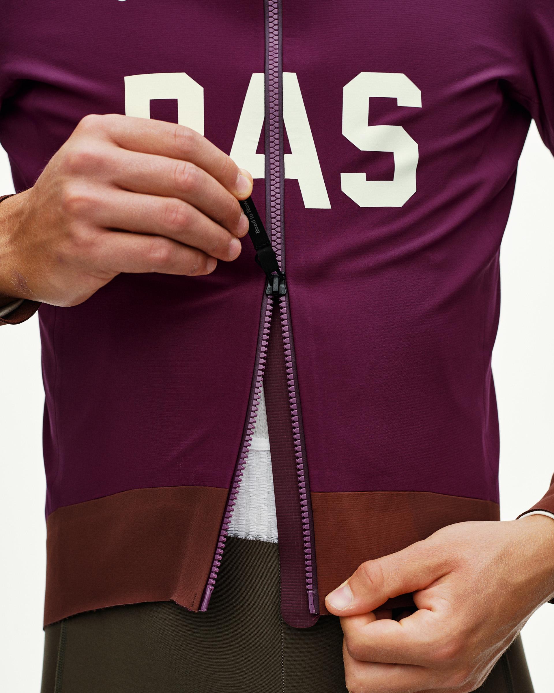 Dark Purple PAS Mechanism Thermal cycling jacket, front detail on model with open full-length zip and cream chest print