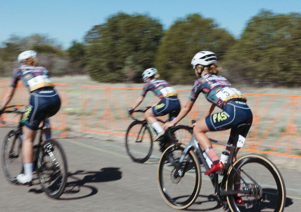 Cyclists racing in multicolored jerseys and navy shorts during Tour of the Gila competition