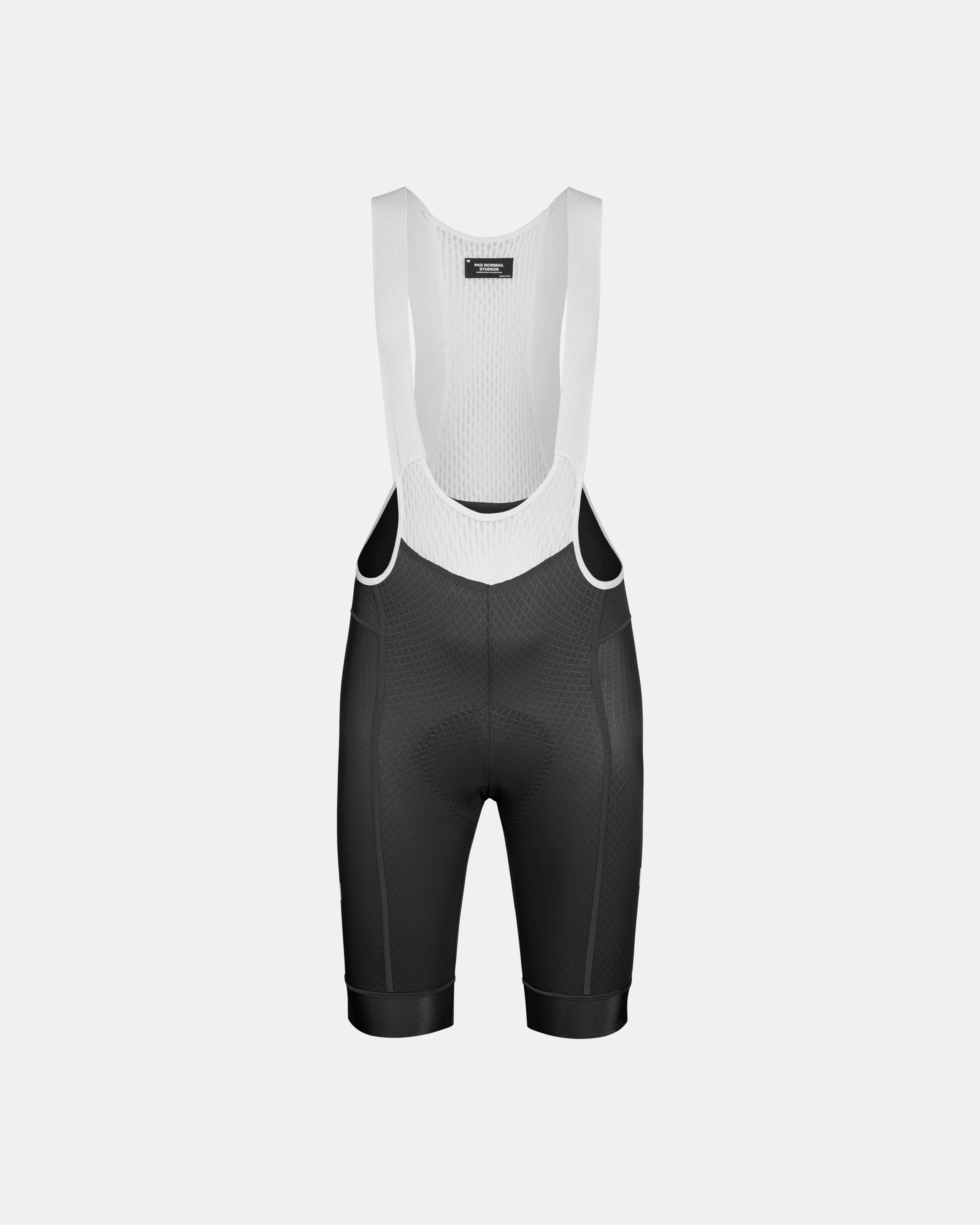 Black Mechanism cycling bibs, front flat lay with white mesh bib straps