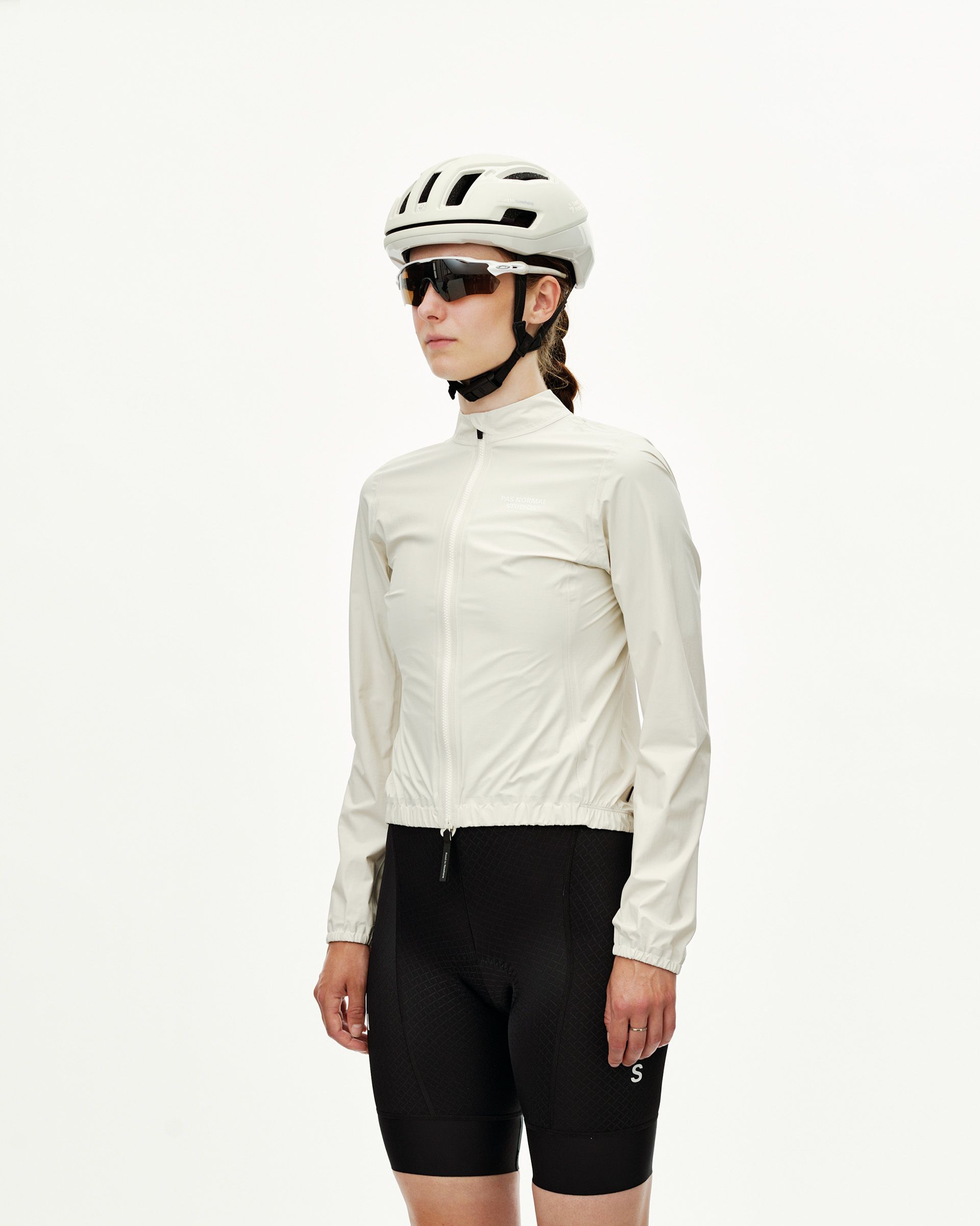 Off White Mechanism women's cycling rain jacket on model, three-quarter front view with full zip and elastic hem