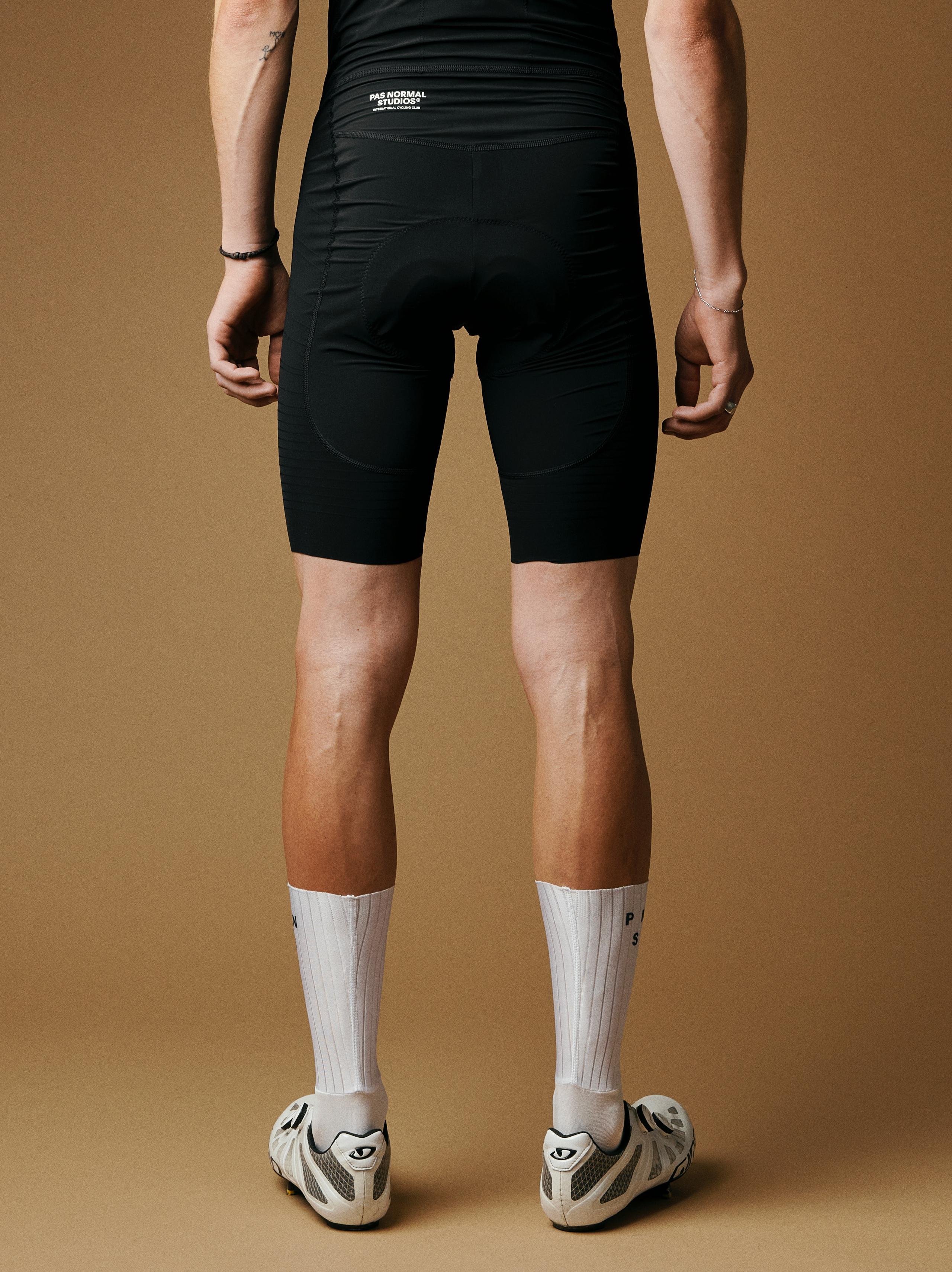 White Mechanism Aero cycling socks on model, rear view with ribbed texture