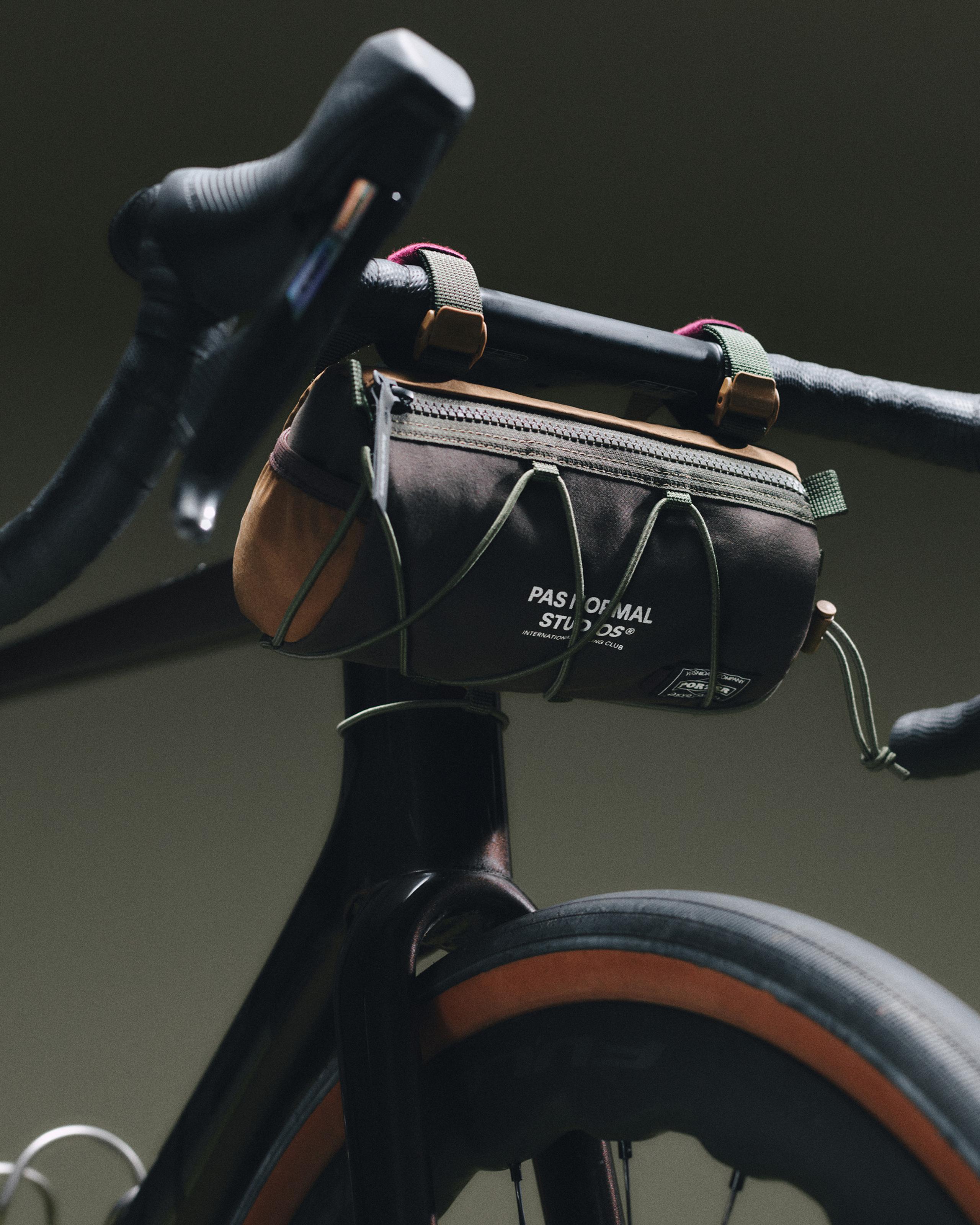 Light Brown Porter-Yoshida handlebar bag mounted on road bike handlebars, front view with green straps and zip top
