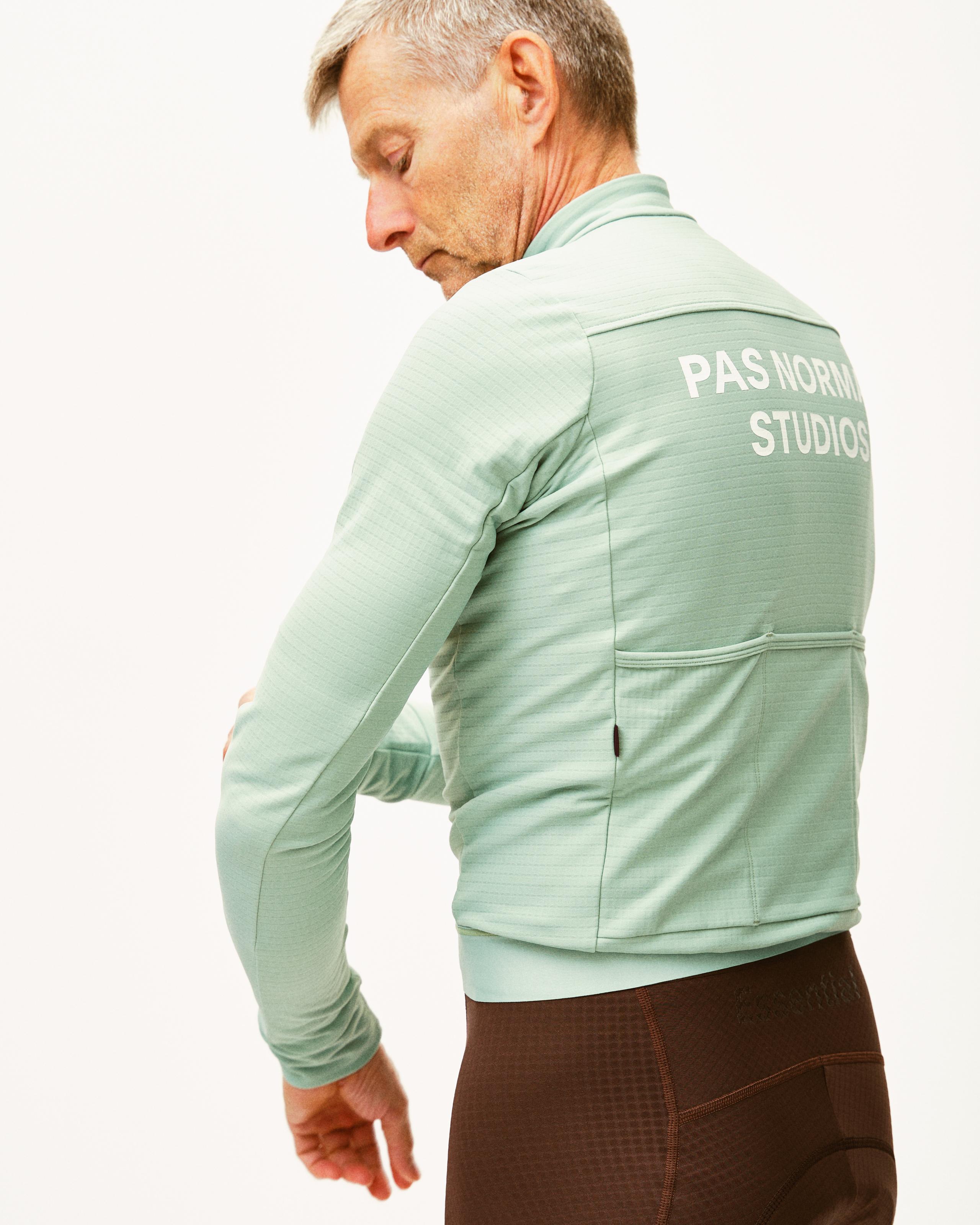 Green Essential long sleeve cycling jersey on model, rear view with white back print