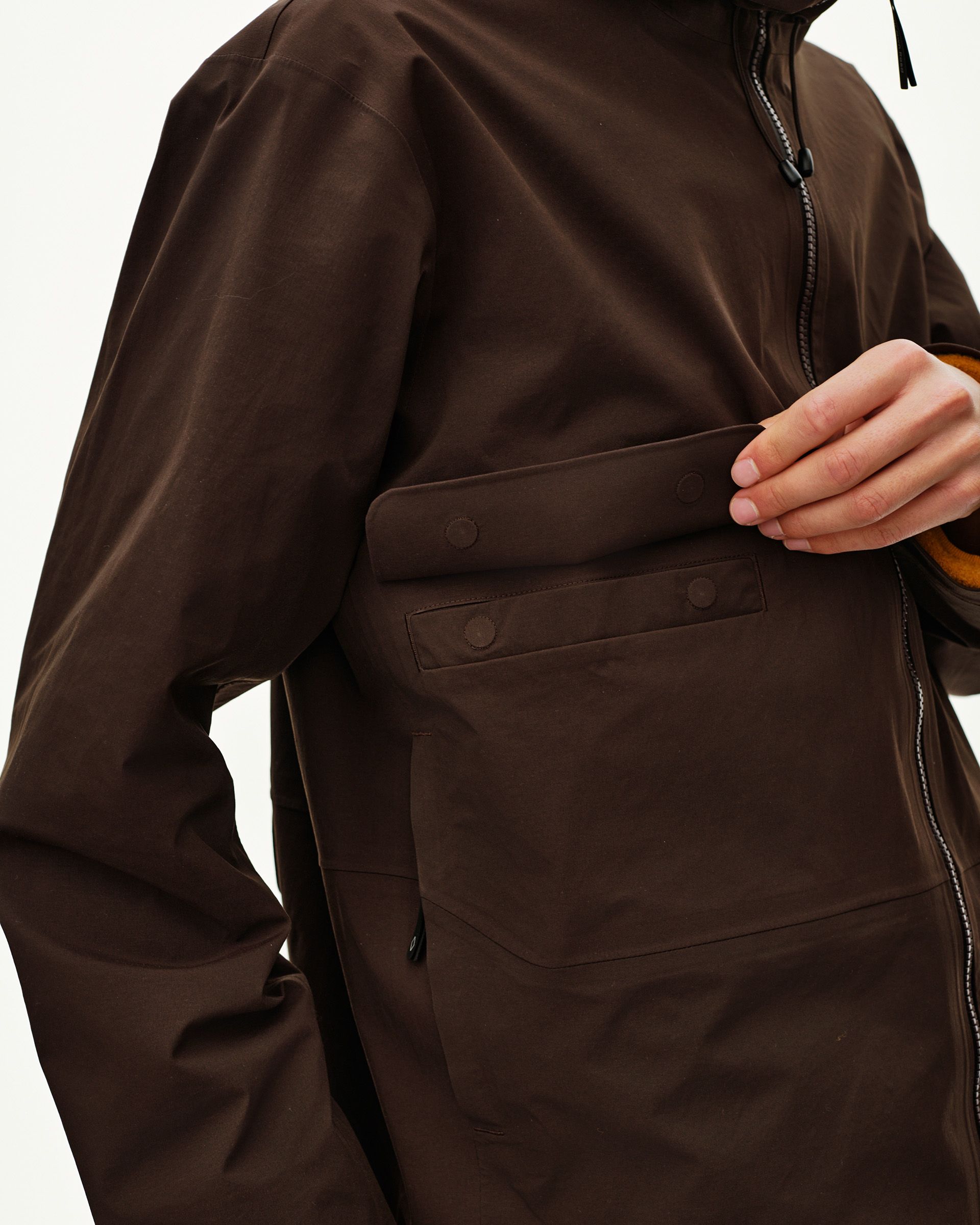 Dark Coffee brown Off-Race 3L Shell jacket on model, front detail view with snap-closure chest pocket and contrast zip