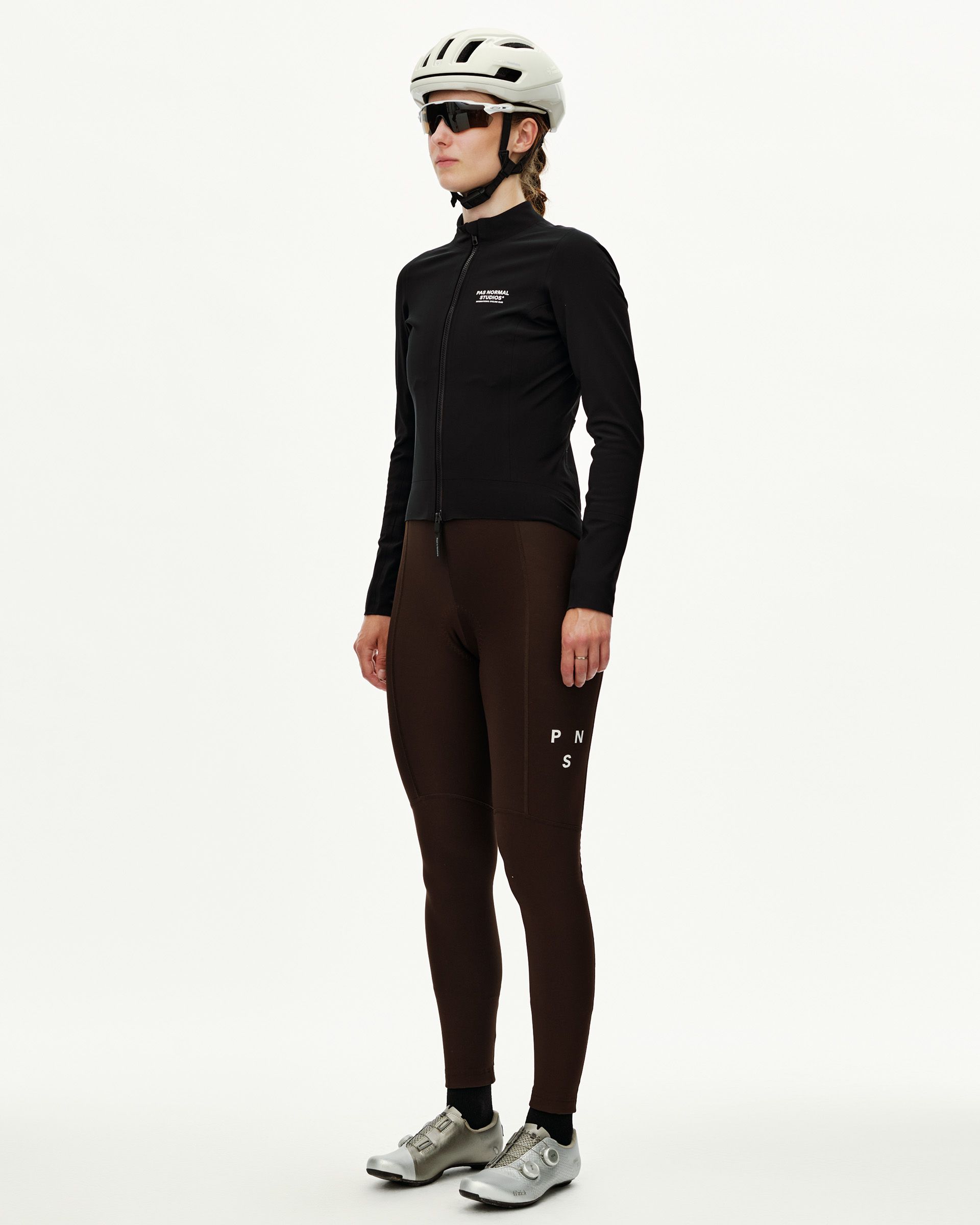 Black Mechanism women's thermal cycling jacket on model, three-quarter front view with full zip and chest logo print
