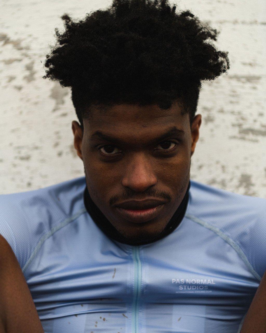 Model wearing blue cycling jersey with zip detail and logo branding