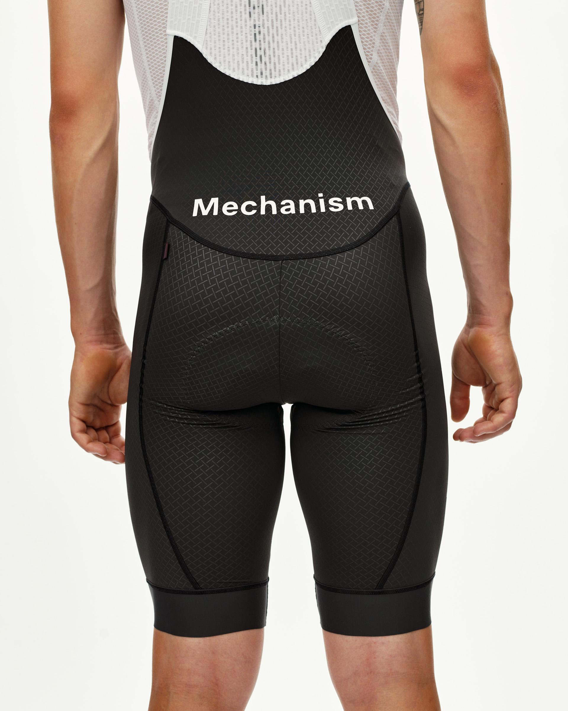 Dark Navy Mechanism cycling bibs on model, rear view with white logo waistband and textured panel