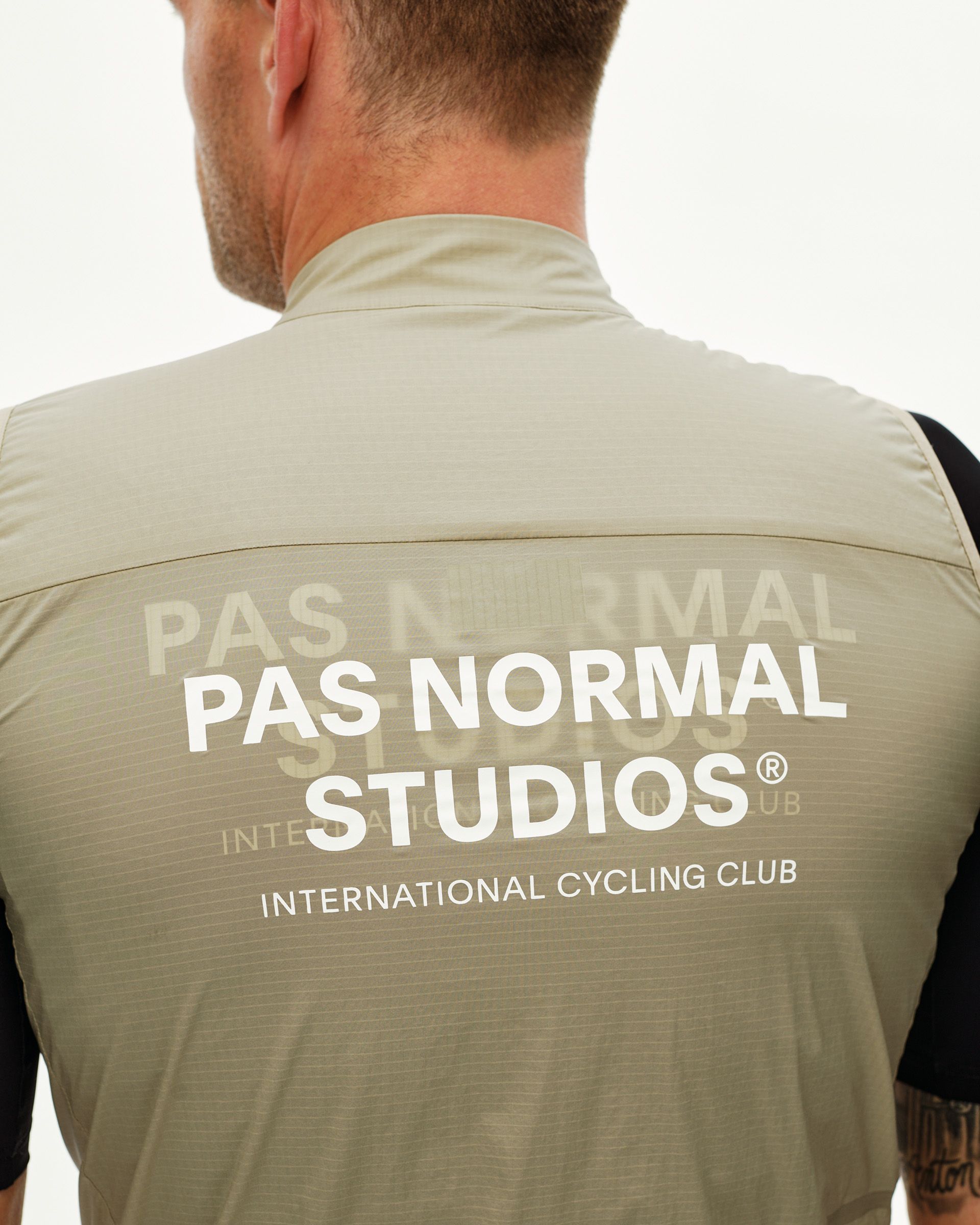 Grey Sage Essential cycling gilet on model, rear view with large white logo print