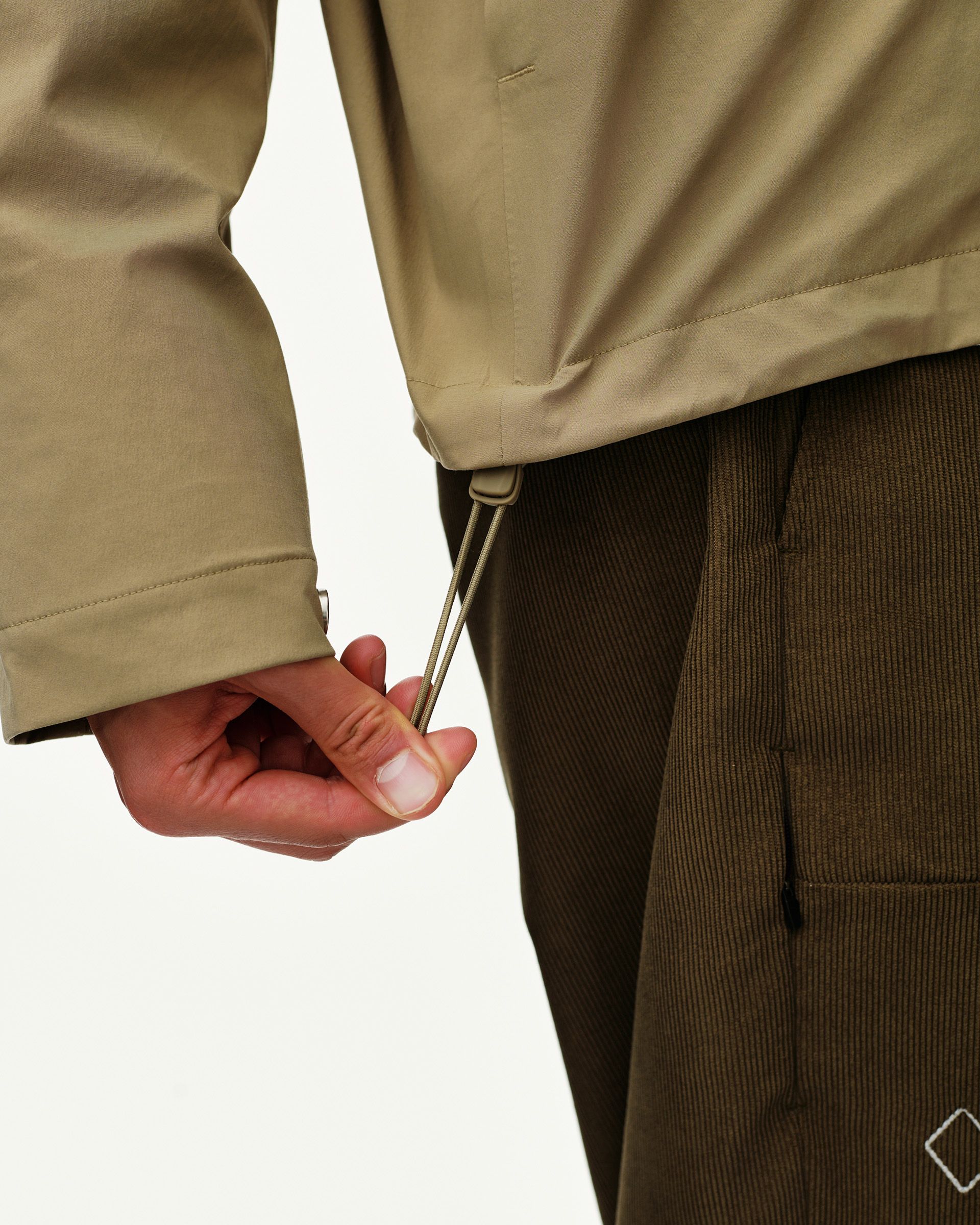Dusty Earth khaki Off-Race 3L Shell jacket, side detail on model showing hem drawcord adjuster