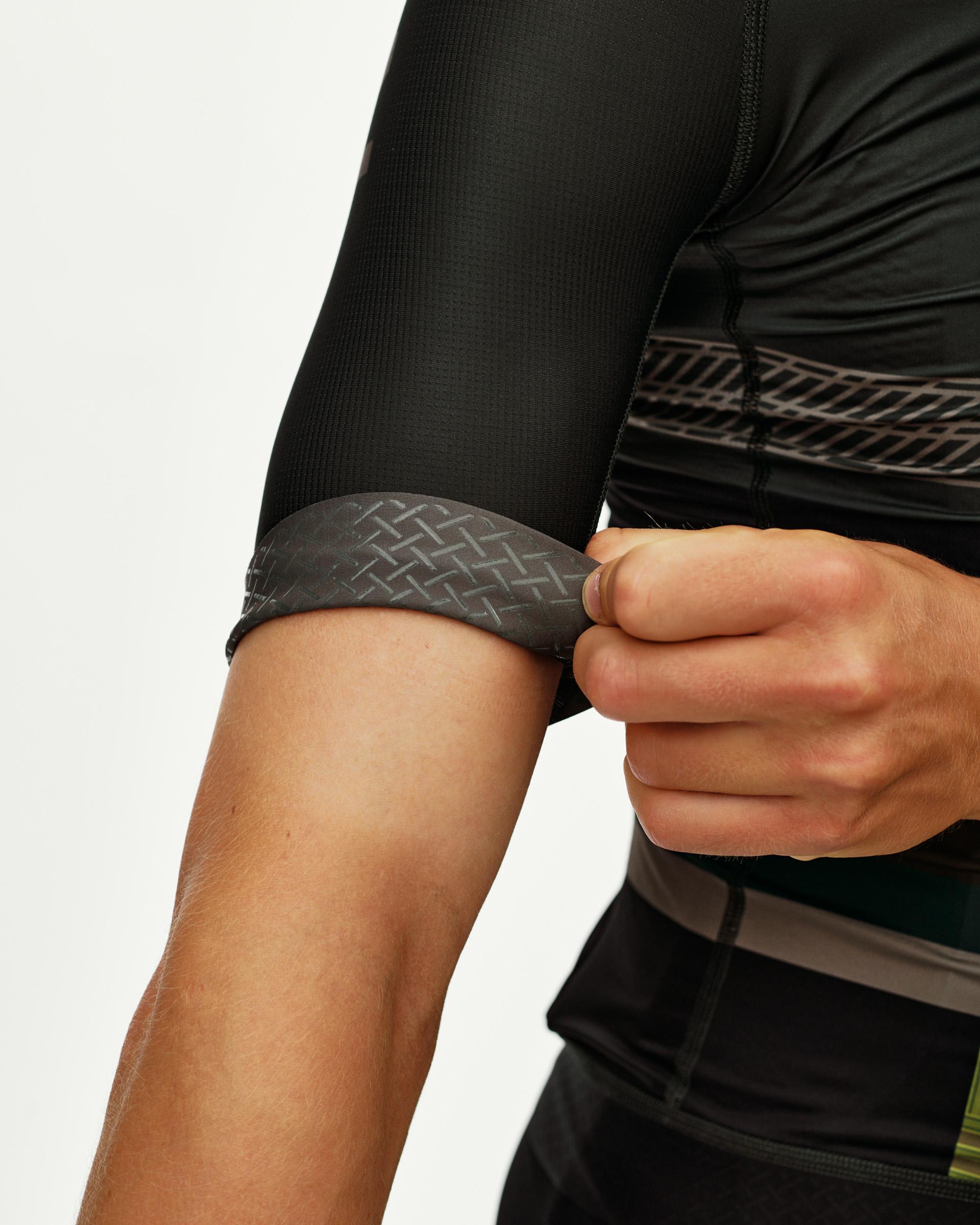 International Earth black Mechanism cycling jersey, sleeve detail on model showing patterned cuff band