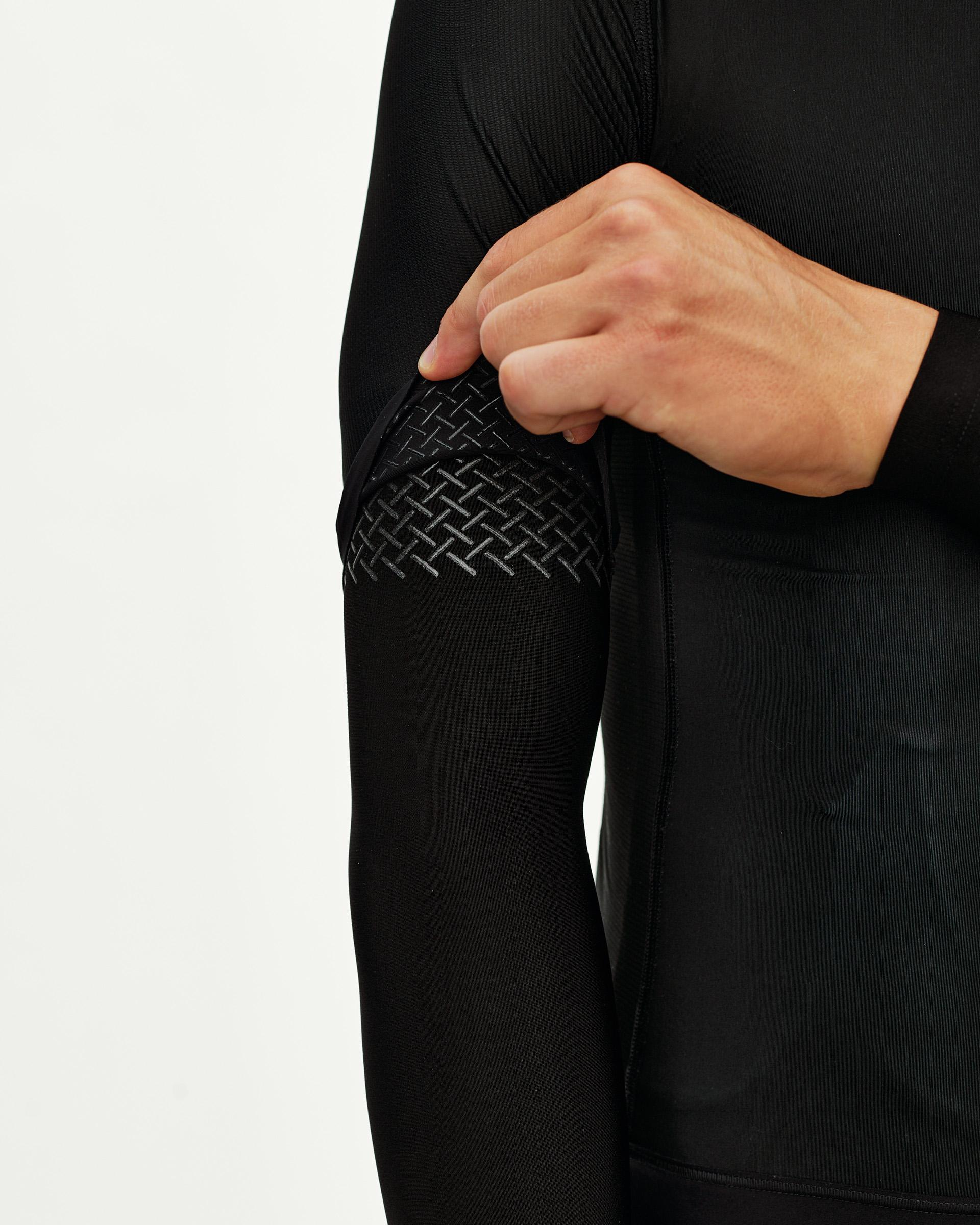 Black Logo cycling arm warmers, detail view on model showing textured logo grip panel