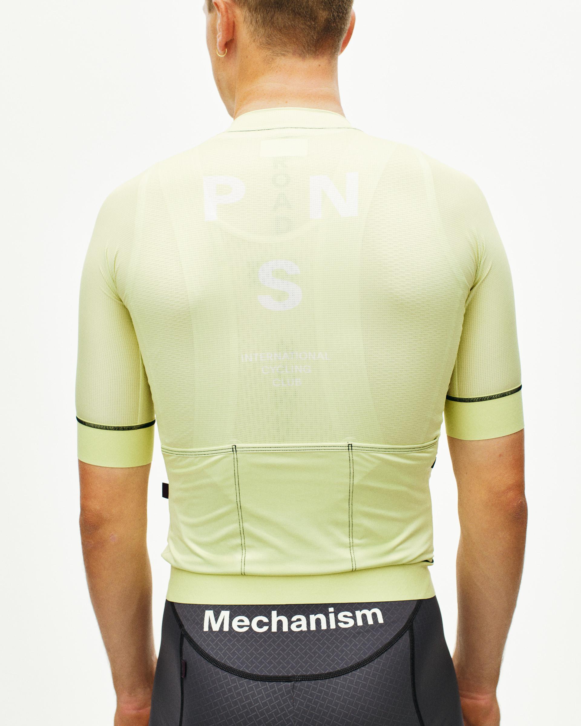 Green Mechanism cycling jersey, rear view on model with white logo print and rear pockets