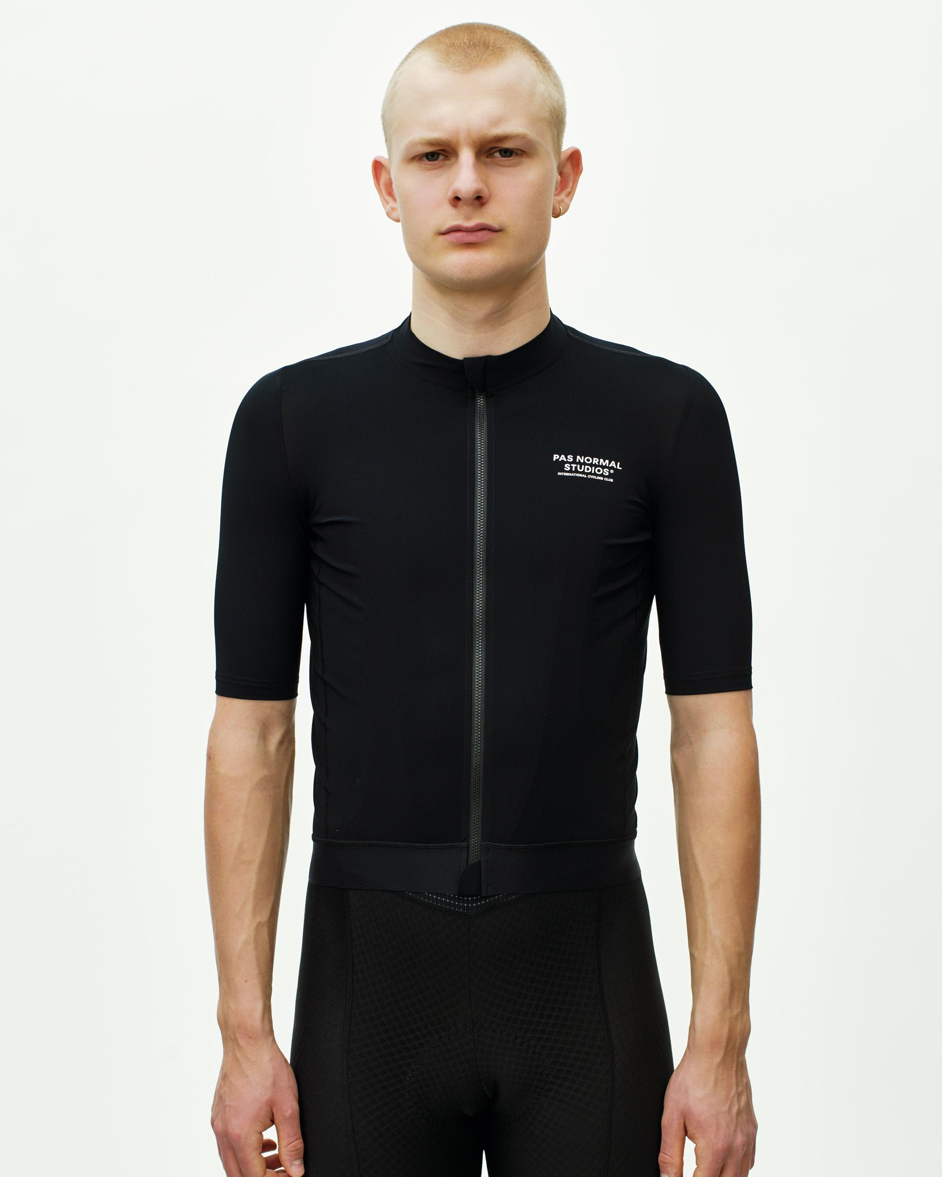Black Essential cycling jersey on model, front view with white chest logo