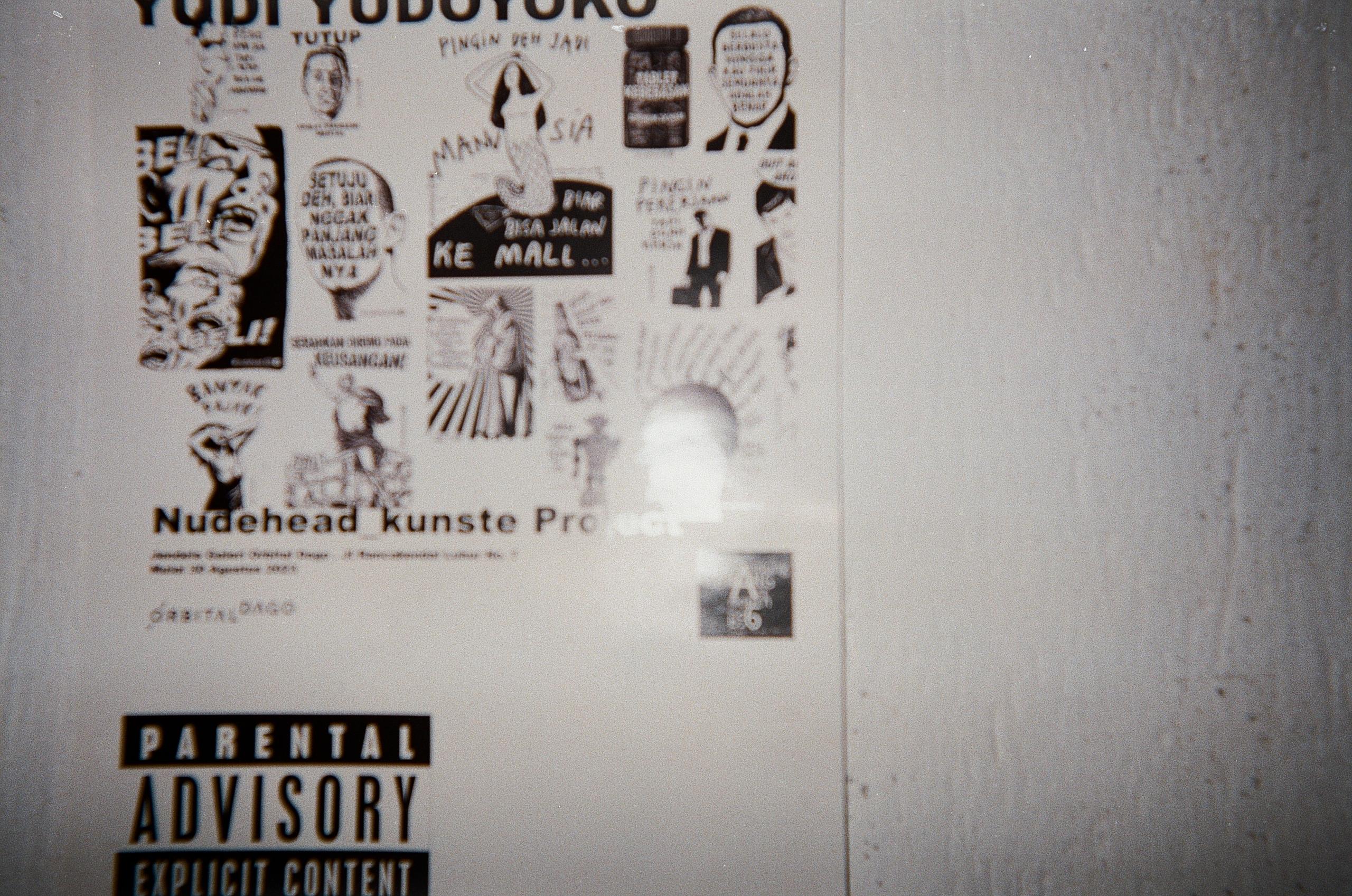 Wall with art posters and parental advisory sticker