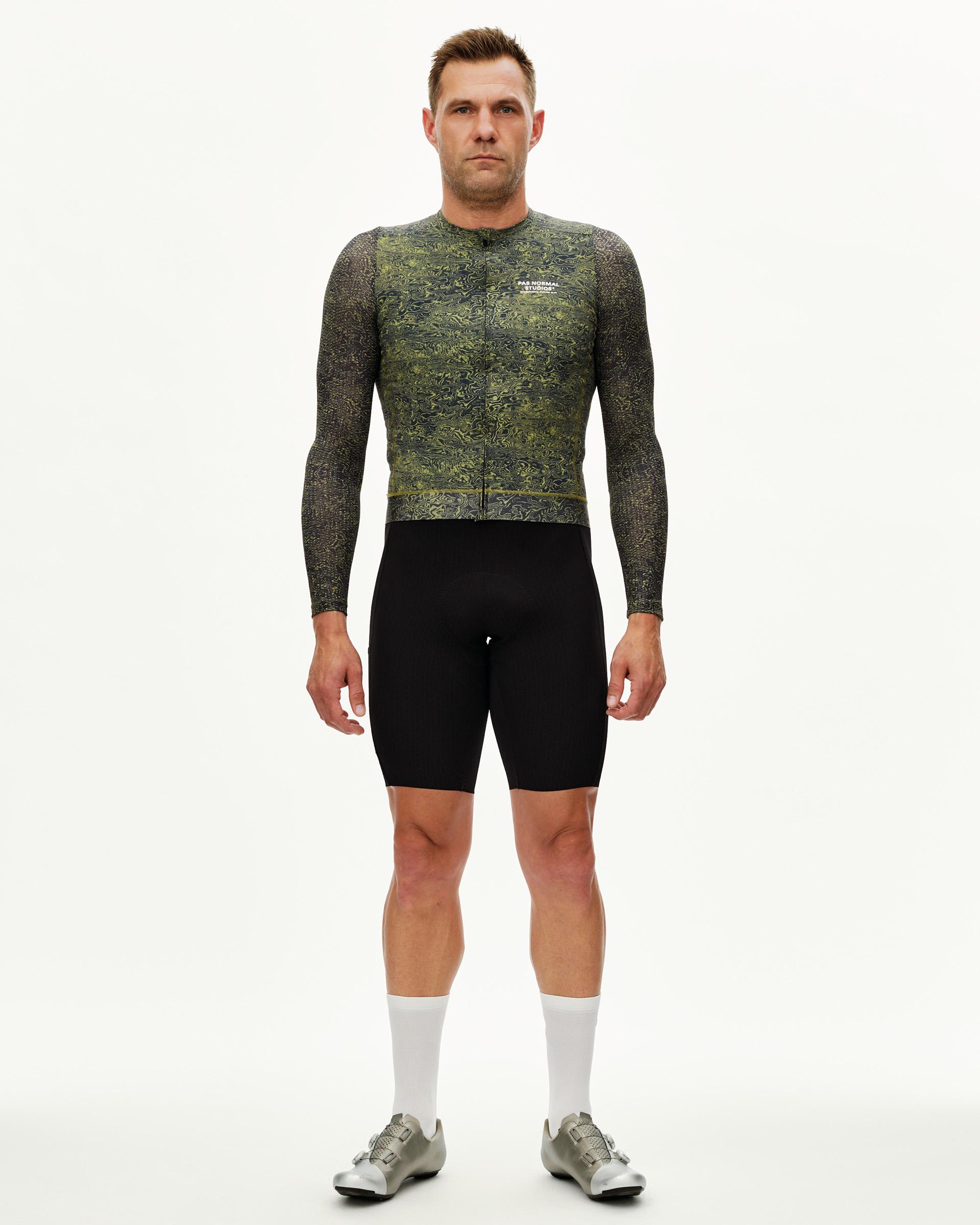 Dark Lime Essential long sleeve cycling jersey on model, front view with all-over swirl print