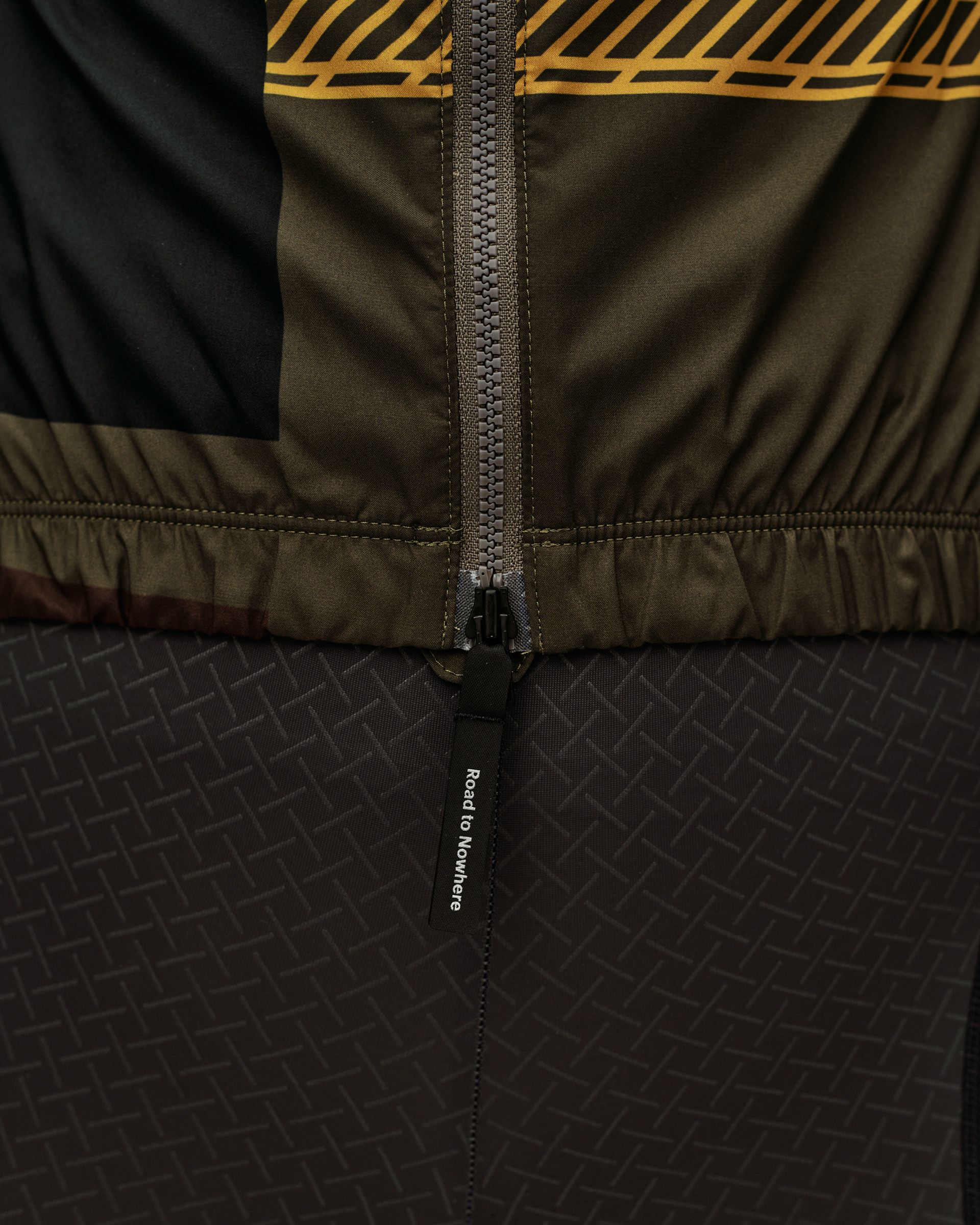 International Green Mechanism Stow Away women's cycling jacket, detail view of front zip with Road to Nowhere zip pull