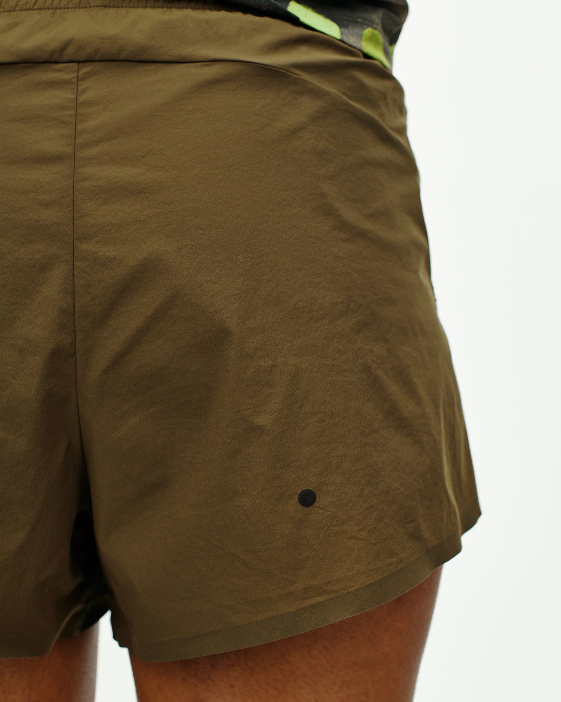 Dark Stone T.K.O. Balance shorts, side view on model with black side panel detail