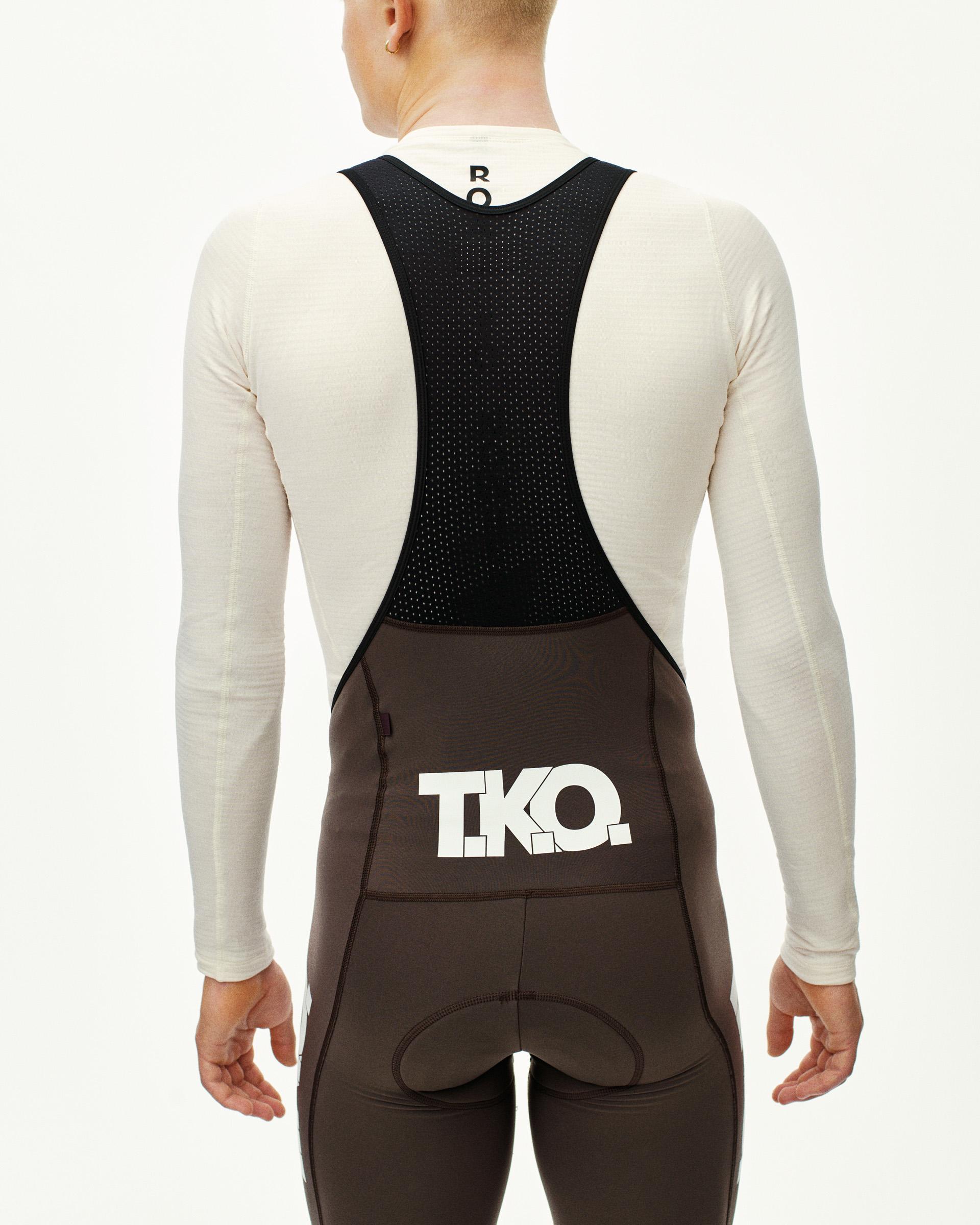 Dark Purple T.K.O. Essential Thermal Long cycling bibs on model, rear view with white logo print and mesh bib panel