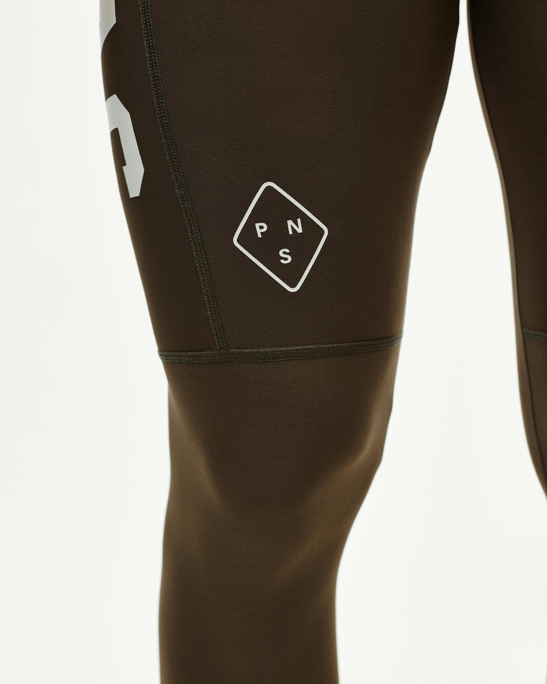 Dark Earth khaki PAS Mechanism Thermal Long cycling bibs, detail view on model with white diamond logo print