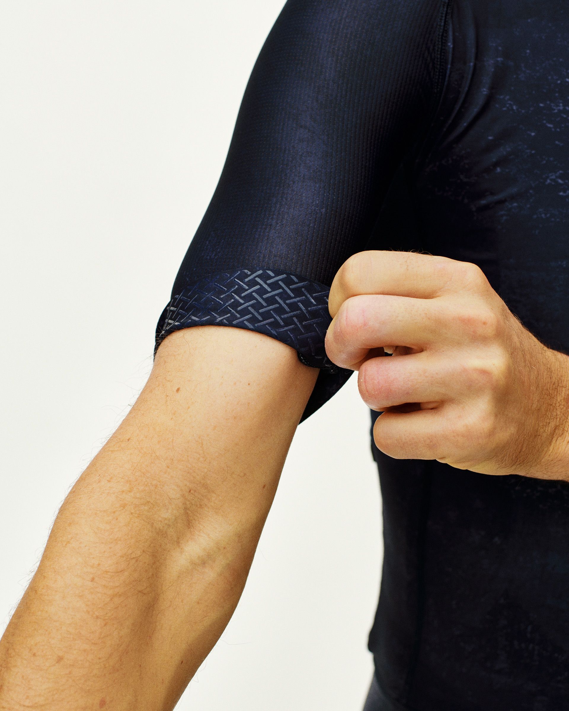 Navy Mechanism cycling jersey on model showing geometric pattern cuff detail