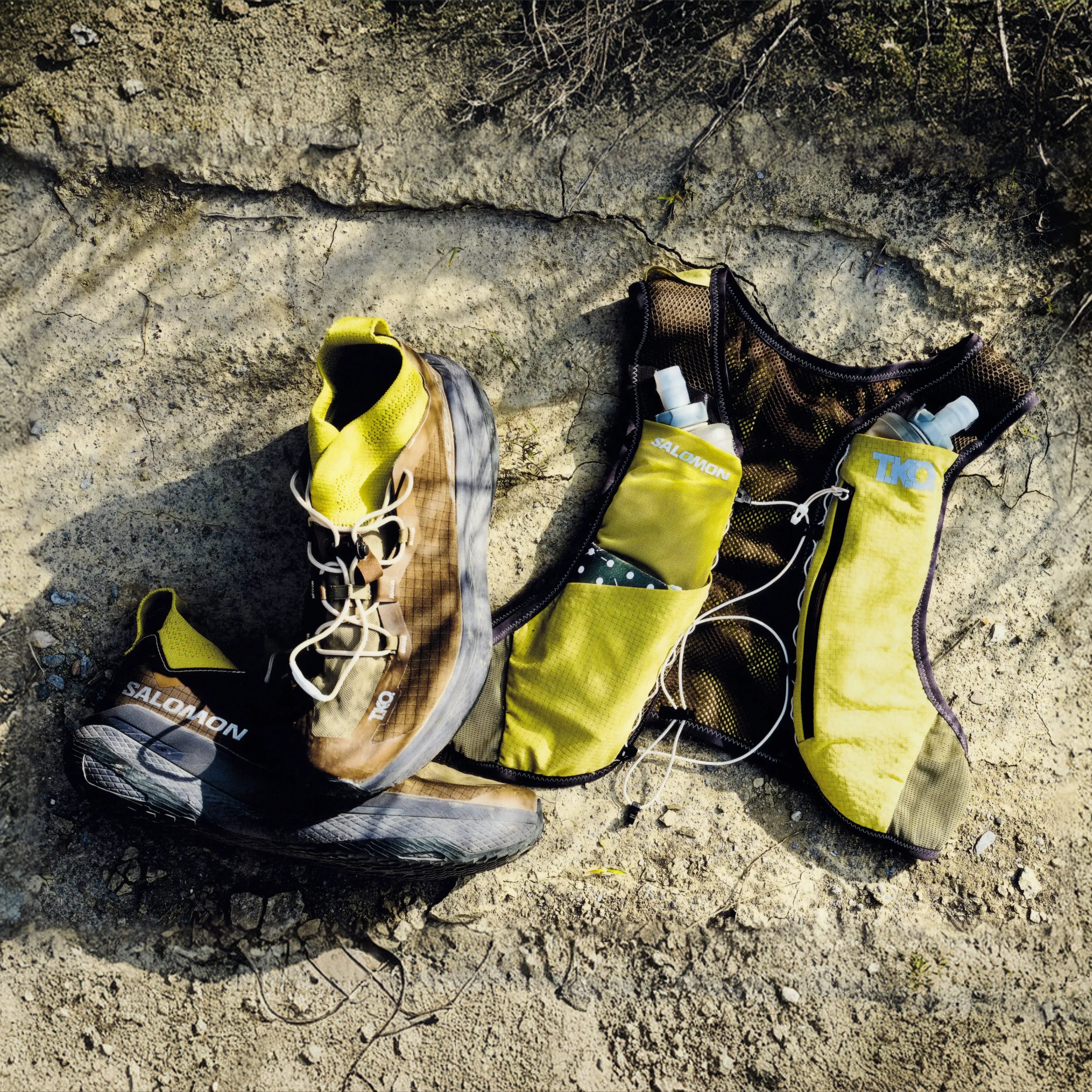 Yellow Salomon T.K.O. GRVL CONCEPT running vest flat lay with water bottles