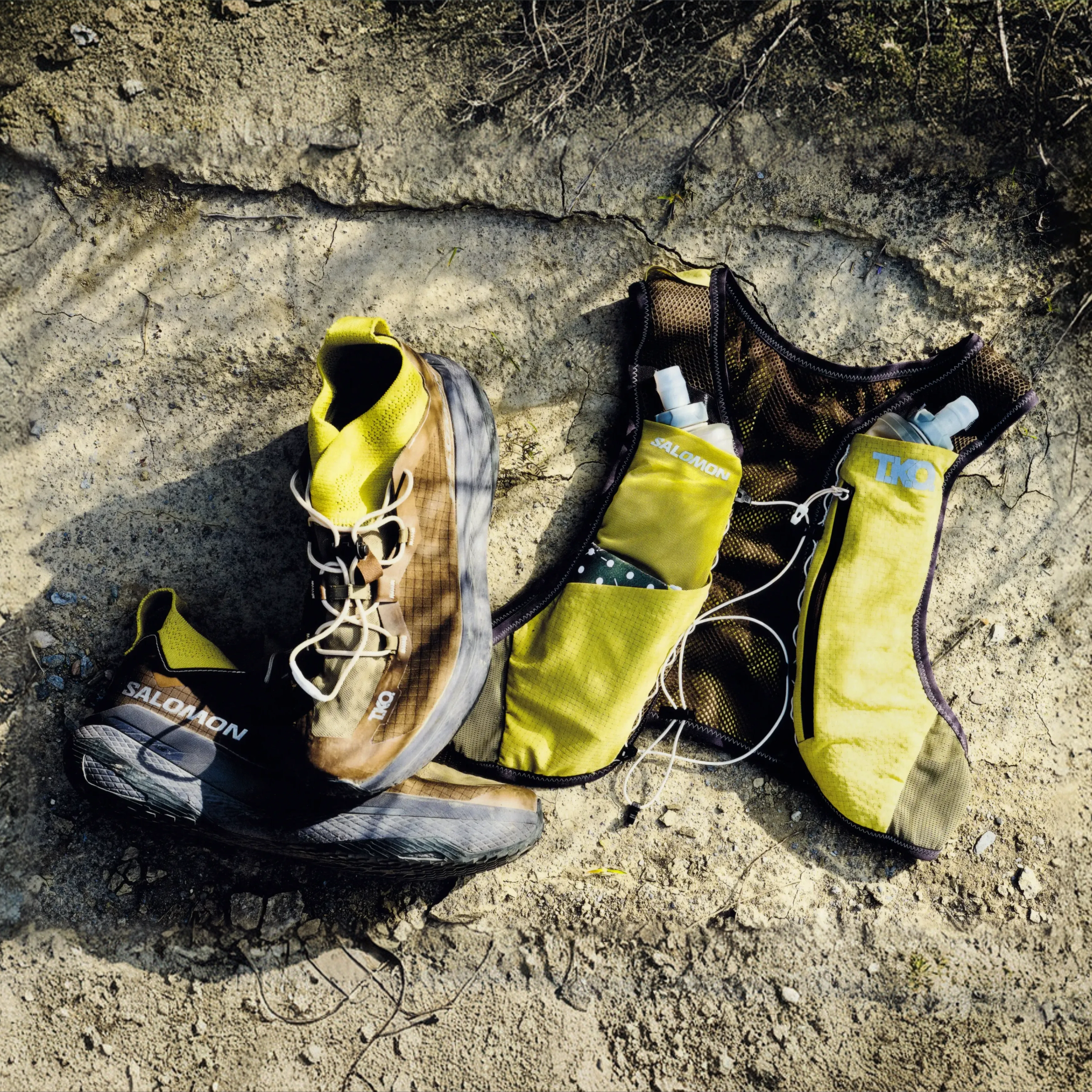 Yellow Salomon T.K.O. GRVL CONCEPT running vest flat lay with water bottles