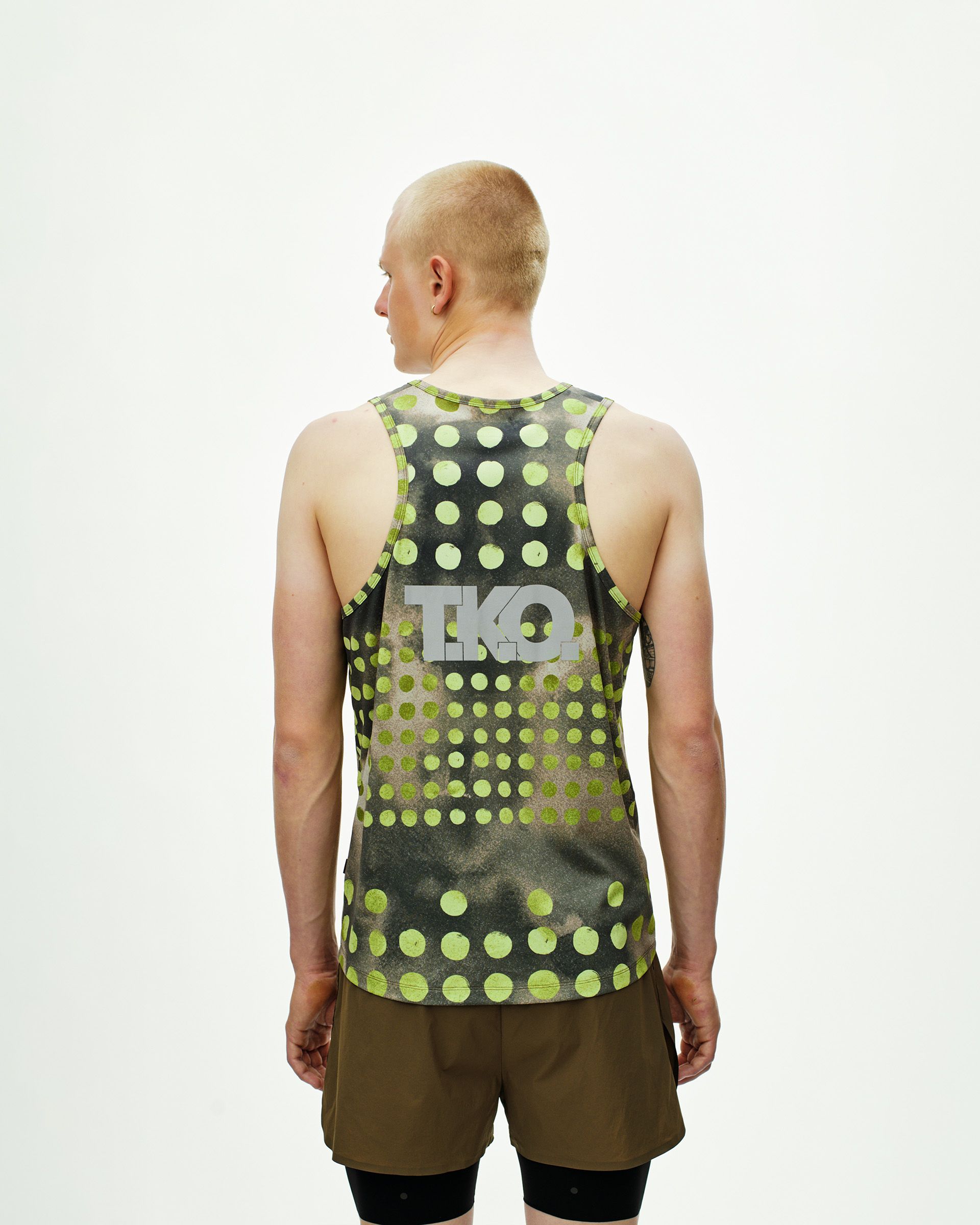 Green T.K.O. Balance singlet, rear view on model with polka dot print and grey logo