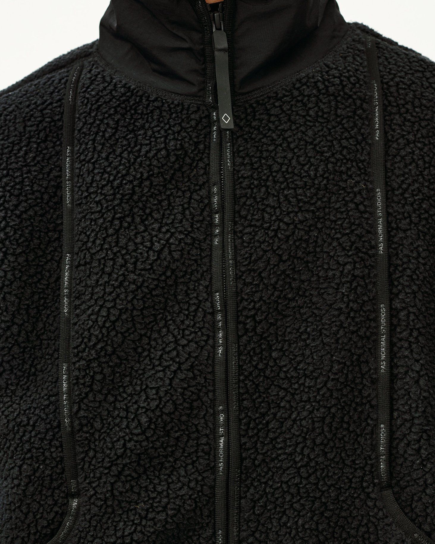 Black Off-Race Pile Fleece jacket, detail view of full zip and branded tape trim on sherpa fleece