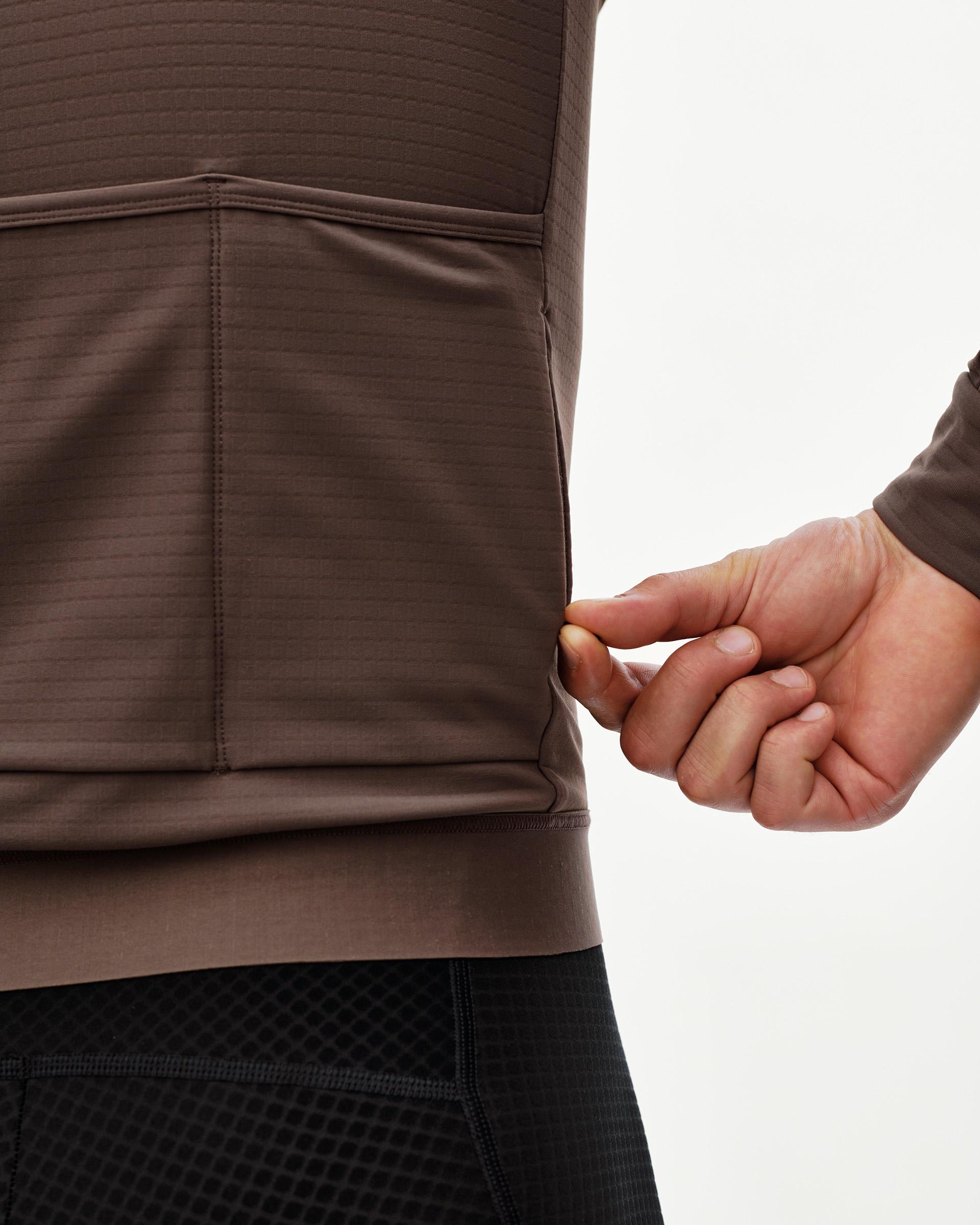 Dusty Plum Essential men's long sleeve cycling jersey, rear detail on model showing ribbed hem panel