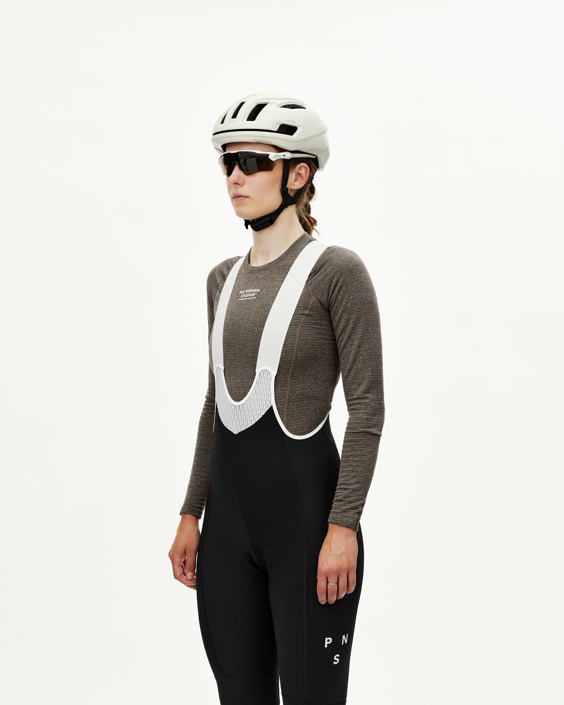 Black Mechanism women's thermal long cycling bibs on model, front three-quarter view with white bib straps